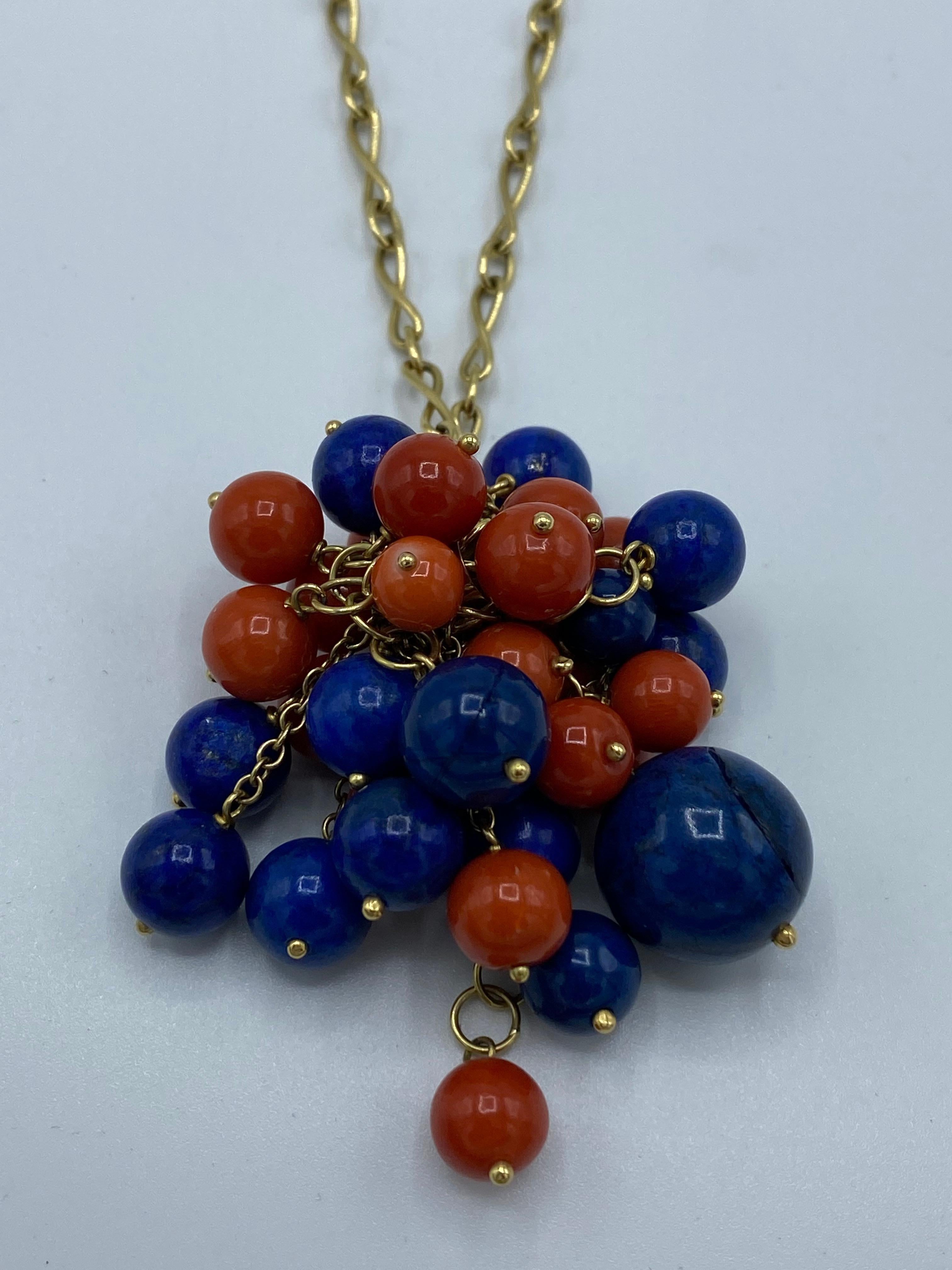 Product details:

The necklace features 18K yellow gold link chain necklace with lapis and coral beads pendant. The pendant is detachable from the chain and both could be worn separately. Some lapis beads have natural inclusions. 
Measurements: the