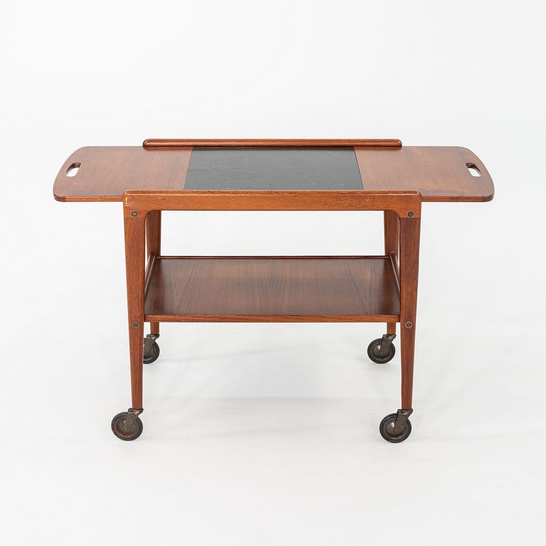 This is a Thea bar and serving cart, designed by Yngve Ekstrom for Kallemo in the 1950s. This particular example dates back to the 1970s. Crafted from teak, the cart reflects Ekstrom's clean Scandinavian sensibility and attention to proportion. The