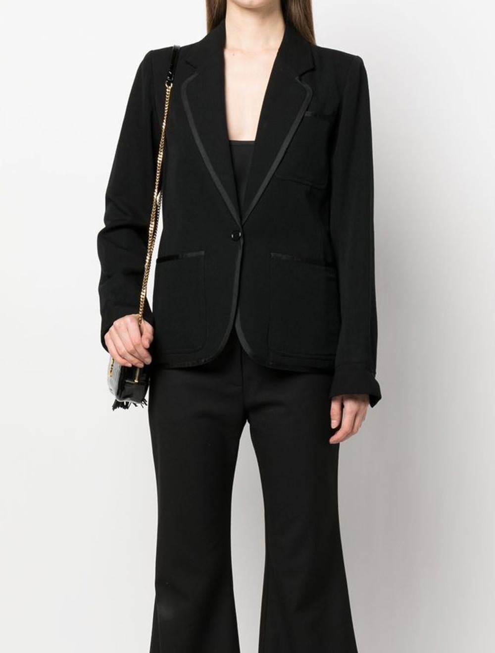 Schwarzer Woll-Smoking-Blazer von YSL Yves Saint Laurent mit folgenden Eigenschaften: kontrastierende Besätze, gekerbtes Revers, Knopfverschluss vorne, aufgesetzte Brusttasche, zwei aufgesetzte Taschen vorne, lange Ärmel, geteilte Manschetten,