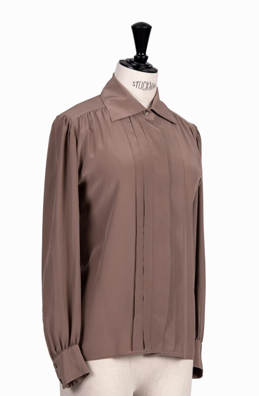 This is a beautiful and classic straight cut silk blouse by Yves Saint Laurent in an amazing tulipwood hue. A true 1970s version! The loose fitting design has all the YSL signature touches – the slightly gathered shoulder and the pleated center