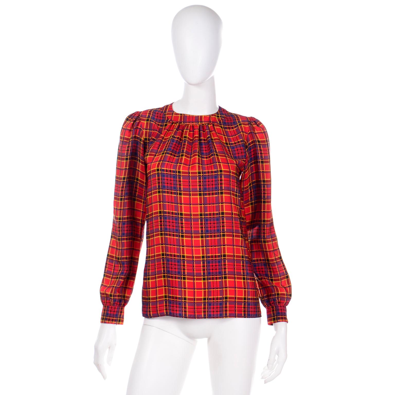 This vintage late 1970's Yves Saint Laurent Rive Gauche blouse is in a pretty red, blue and yellow plaid silk. YSL created some of the most beautiful blouses and they are as wearable today as they were 50 years ago. The top has a round collar, YSL's