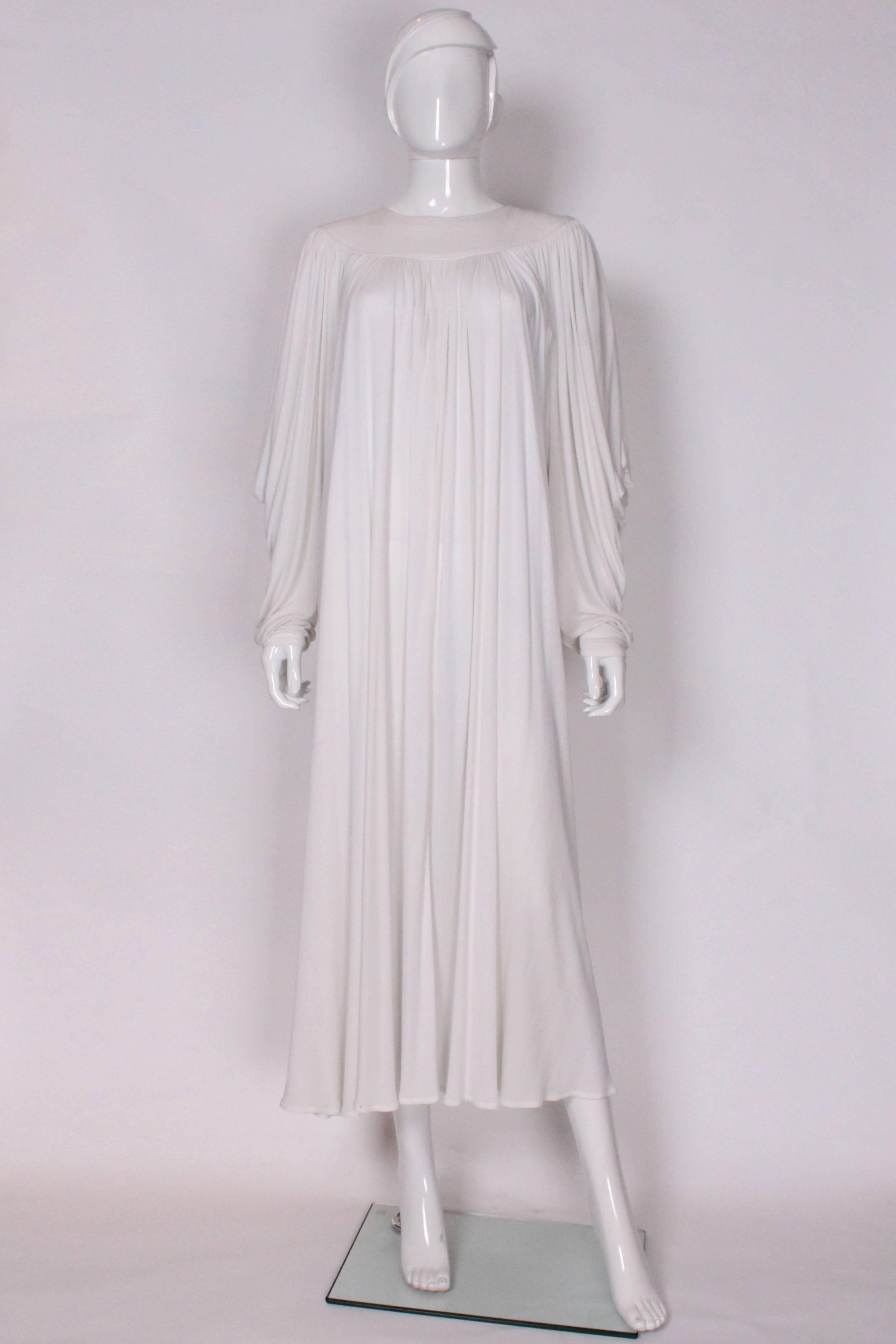 A lovely gown by Gryuki Torimaru under his Yuki London label. The gown is in a white jersey material with a round neckline with rows of stitching on the front and back. The dress opens at the back with 8 buttons and then a sexy keyhole opening. The