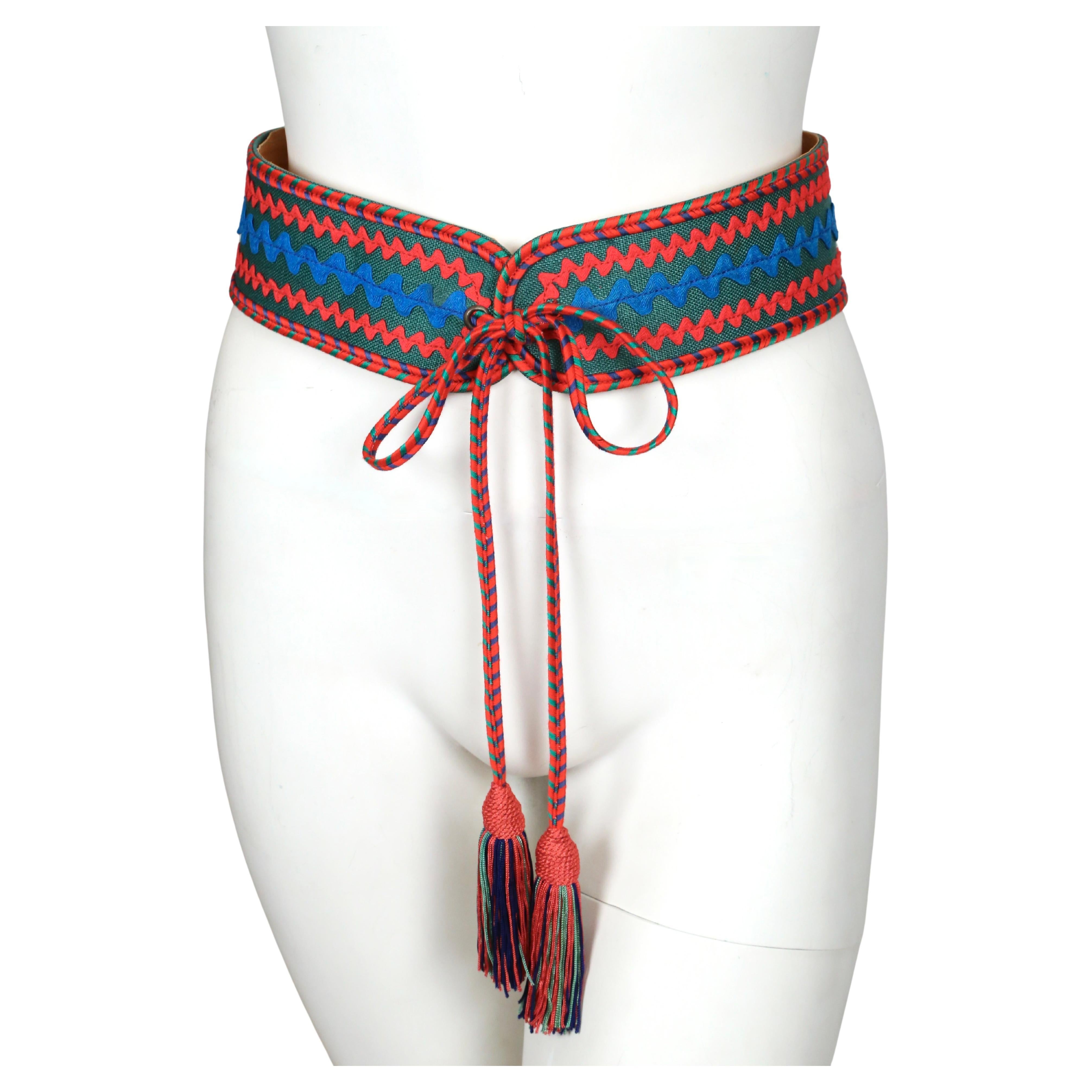 Very interesting fabric belt with ric-rac accents, long ties and multi-colored tassels from Yves Saint Laurent dating to the 1970's. Labeled a size '4'. Belt measures approximately: 28.5