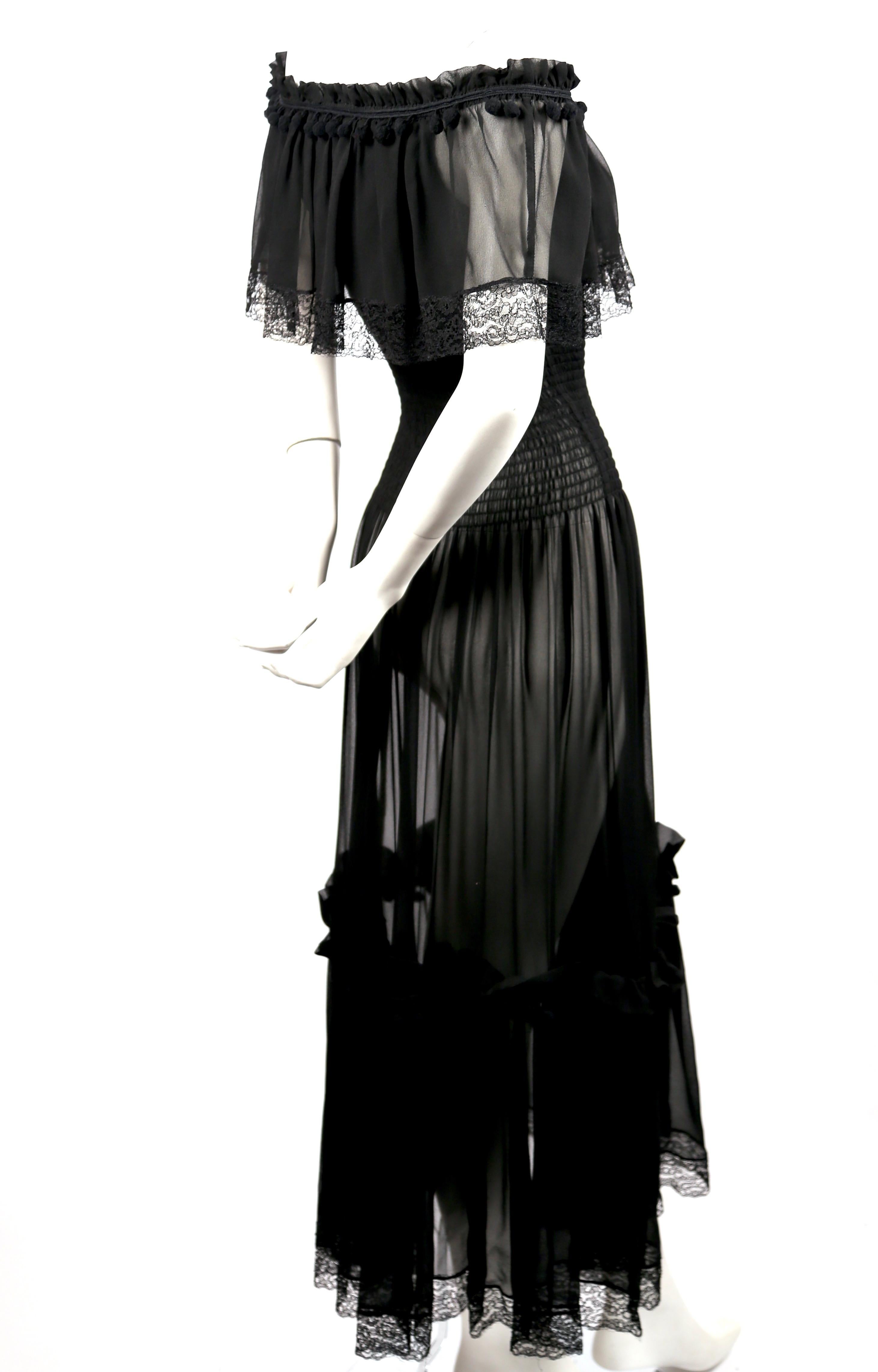 Very rare, semi-sheer, black, silk-chiffon peasant dress with lace trim, pom pom accents and smocked bodice designed by Yves Saint Laurent dating to the 1970's. Neckline is elasticized to be worn off the shoulders. French size 34. Approximate