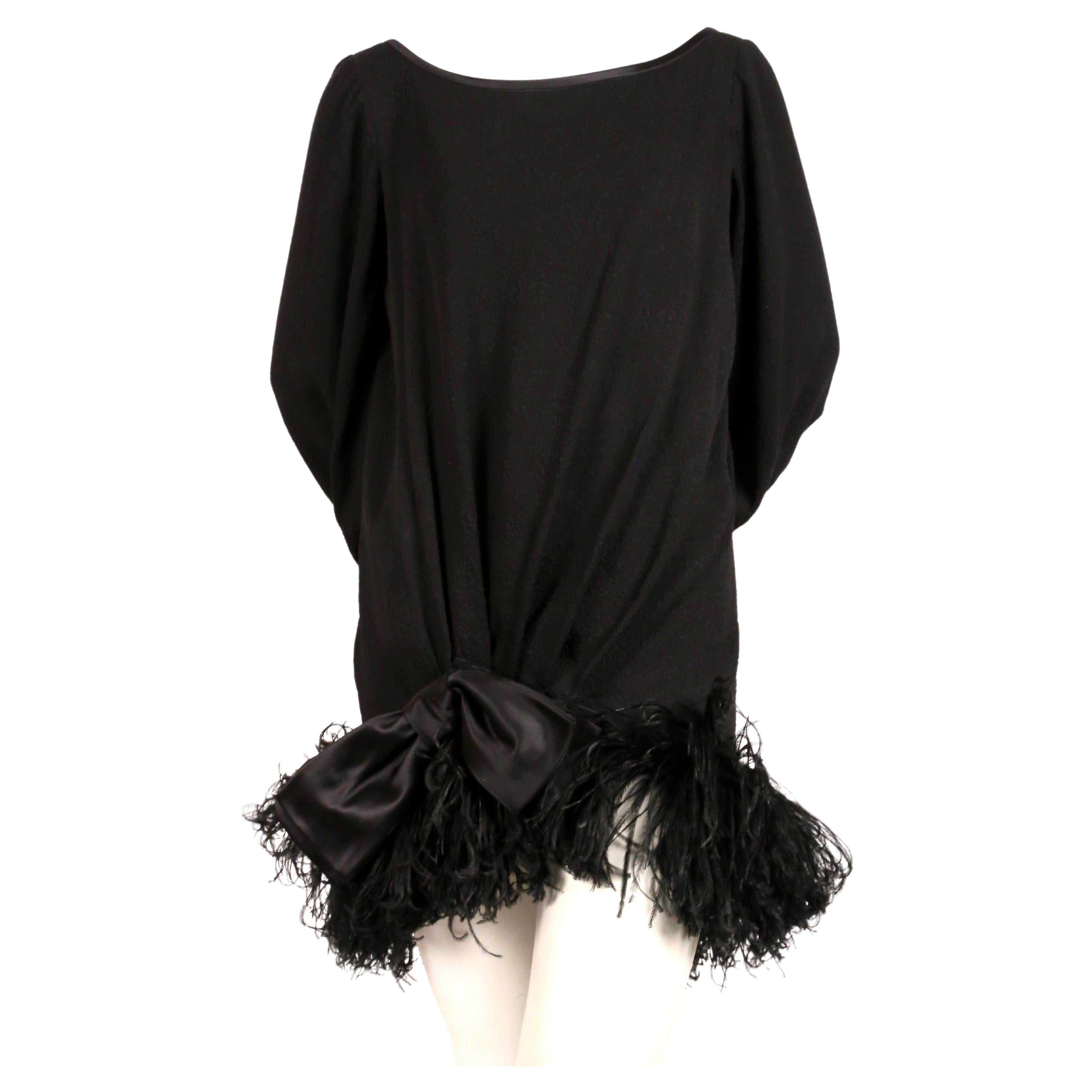 Black crepe silk mini dress with marabou feather trim and satin bow designed by Yves Saint Laurent dating to the late 1970's. Labeled a French size 38. Approximate measurements: shoulder 15.5