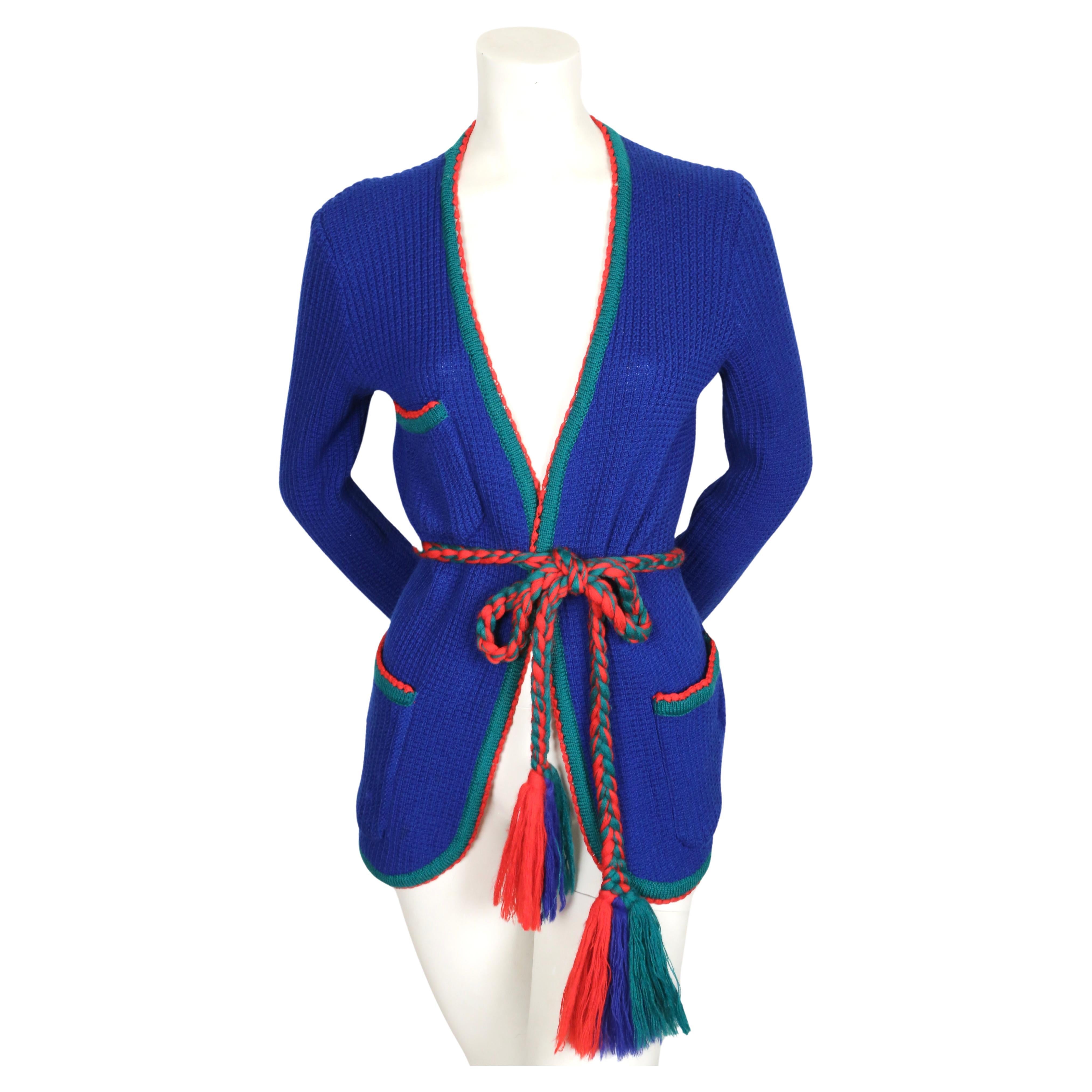 Pull cardigan côtelé bleu vif, vert et rouge avec poches plaquées et ceinture tressée conçu par Yves Saint Laurent datant des années 1970. Labellisé de taille 
