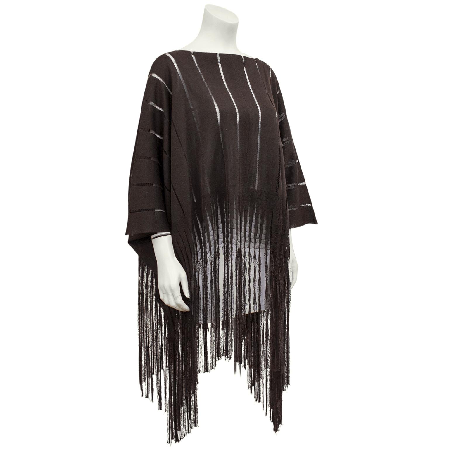 1970s Yves Saint Laurent bohemian brown poncho. Oversized, with a boat neckline, an wide knit, and a long fringe hem. Bracelet length dolman sleeves. Perfect over jeans and a t-shirt on a spring night for a boho chic look. In excellent vintage