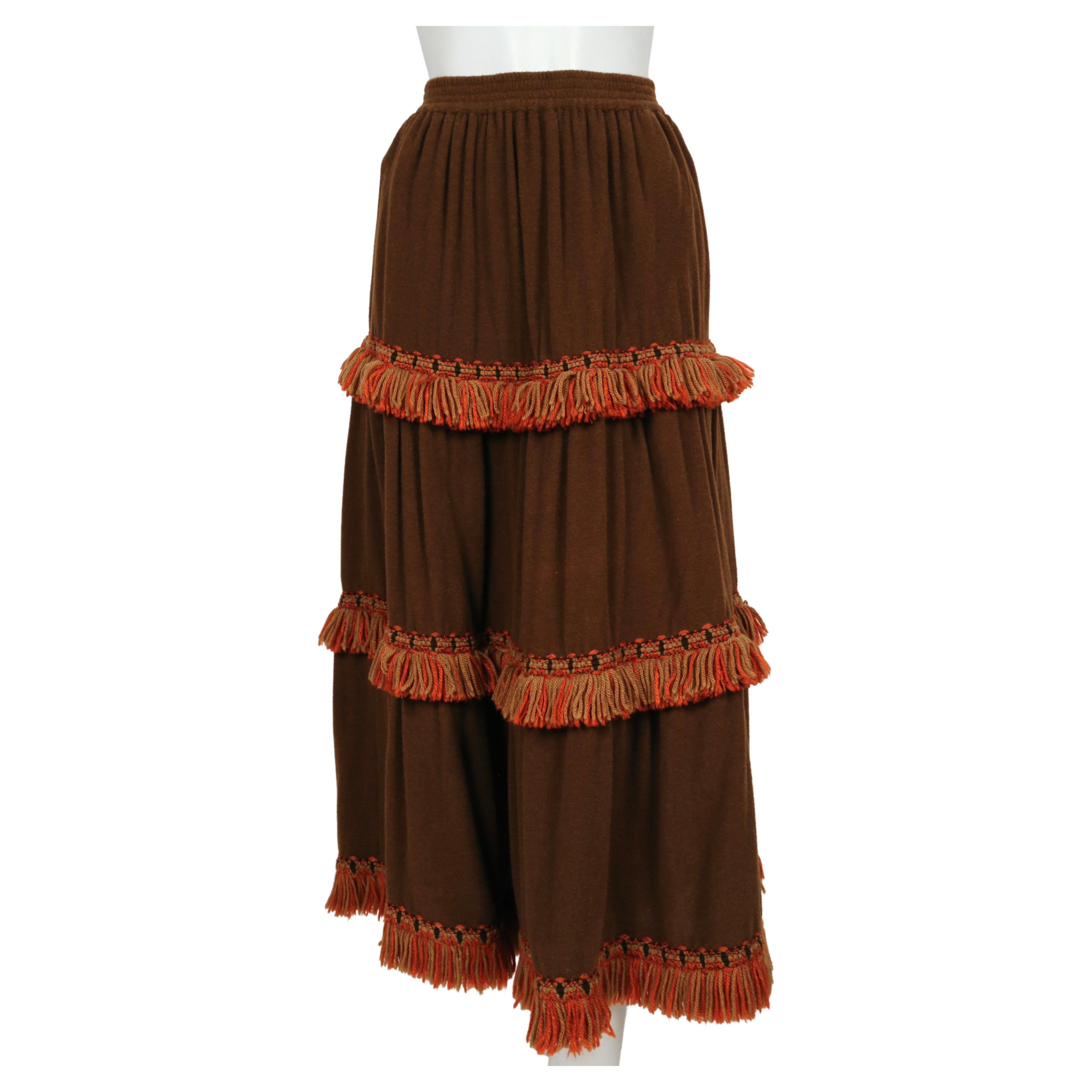 Very soft, rich brown wool skirt with tan and orange fringed yarn trim designed by Yves Saint Laurent dating to the 1970's. Labeled a FR 38. Approximate measurements (unstretched): waist 23.75