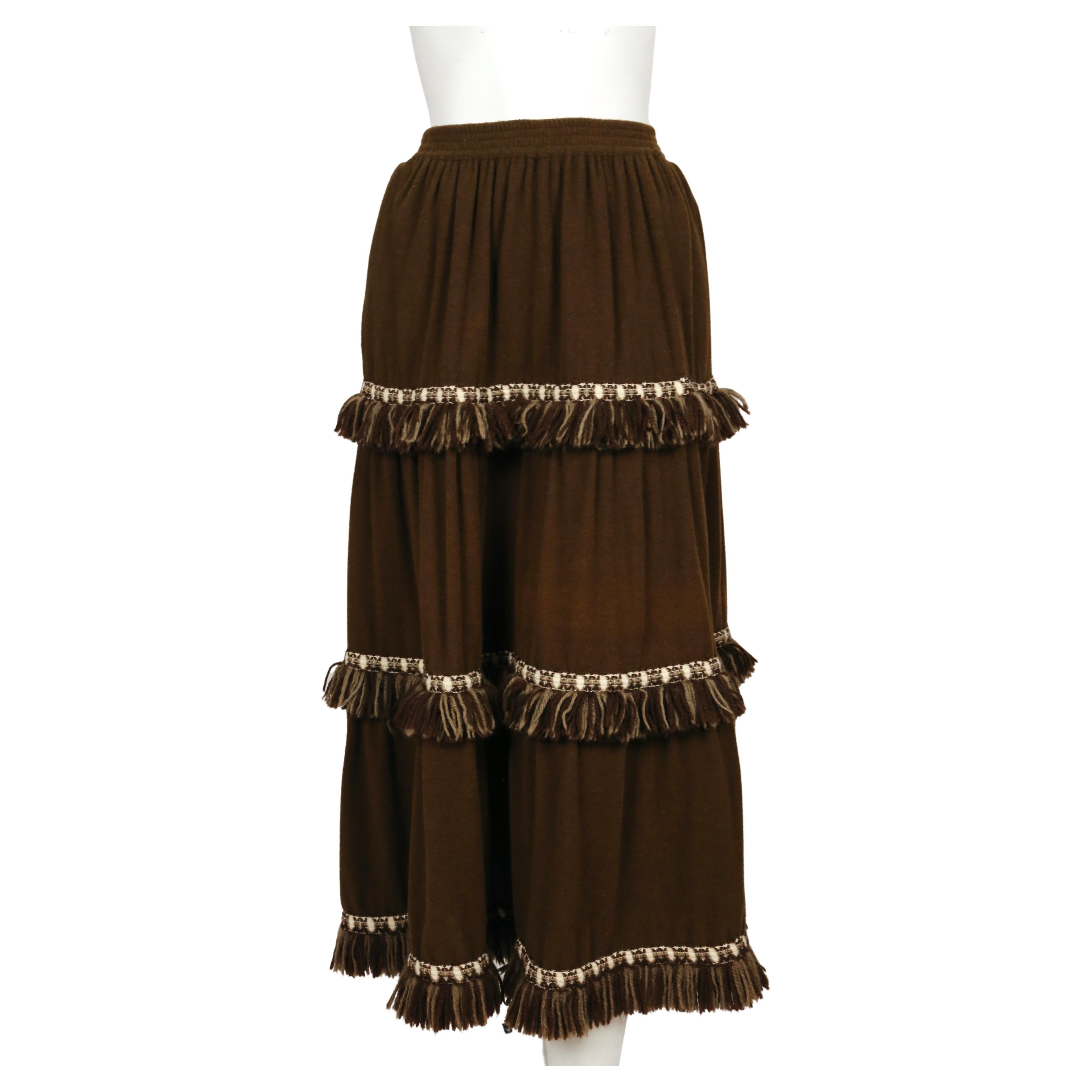 Very soft, rich dark brown wool skirt with cream fringed yarn trim designed by Yves Saint Laurent dating to the 1970's. Labeled a FR 38. Approximate measurements (unstretched): waist 23.75
