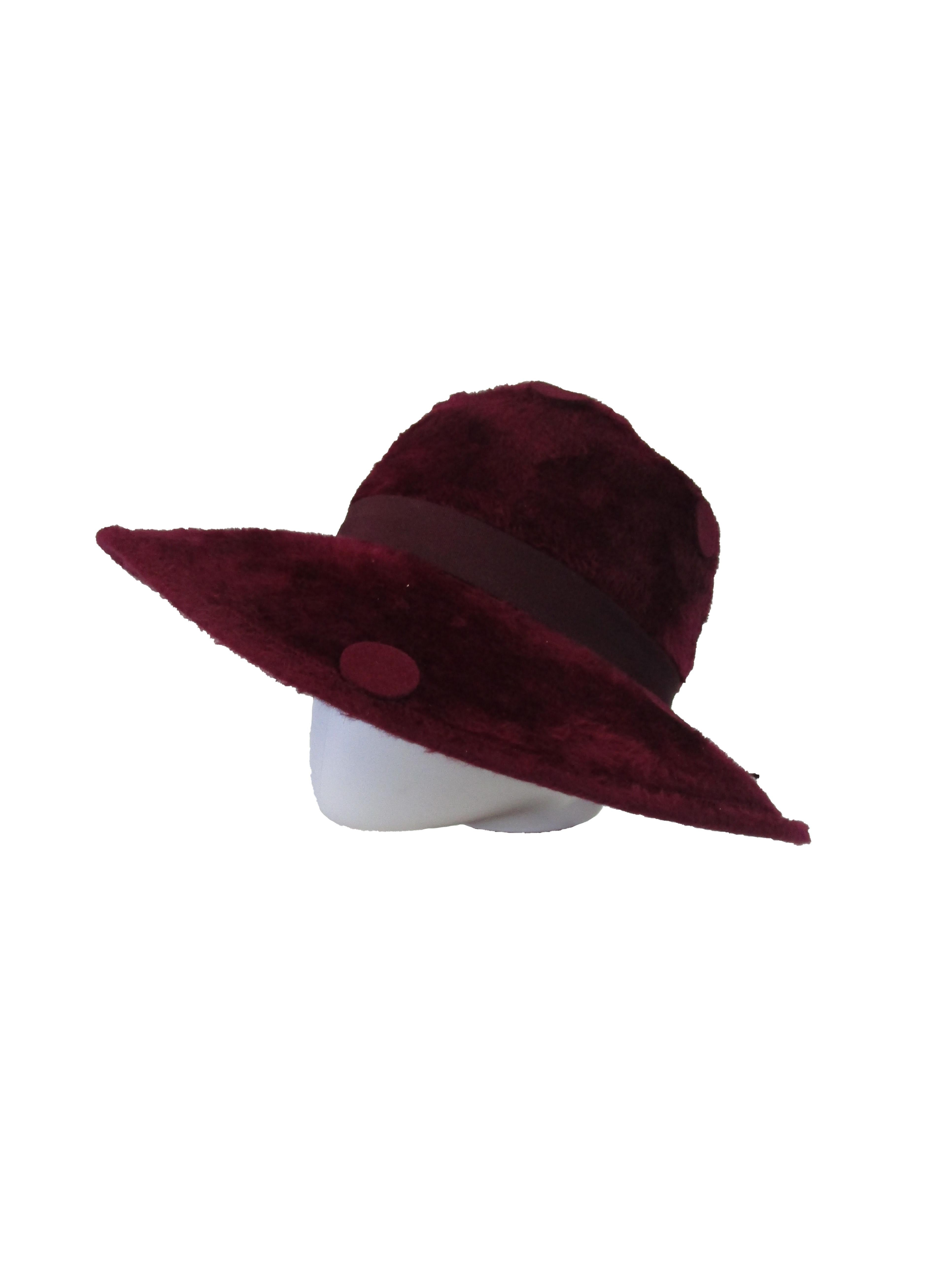 

Check out this effortlessly cool hat from Yves Saint Laurent that will easily liven up your wardrobe! The body of the hat is a wine red *faux* fur that is decorated with large felt dots throughout. A deep red grosgrain band wraps around the hat