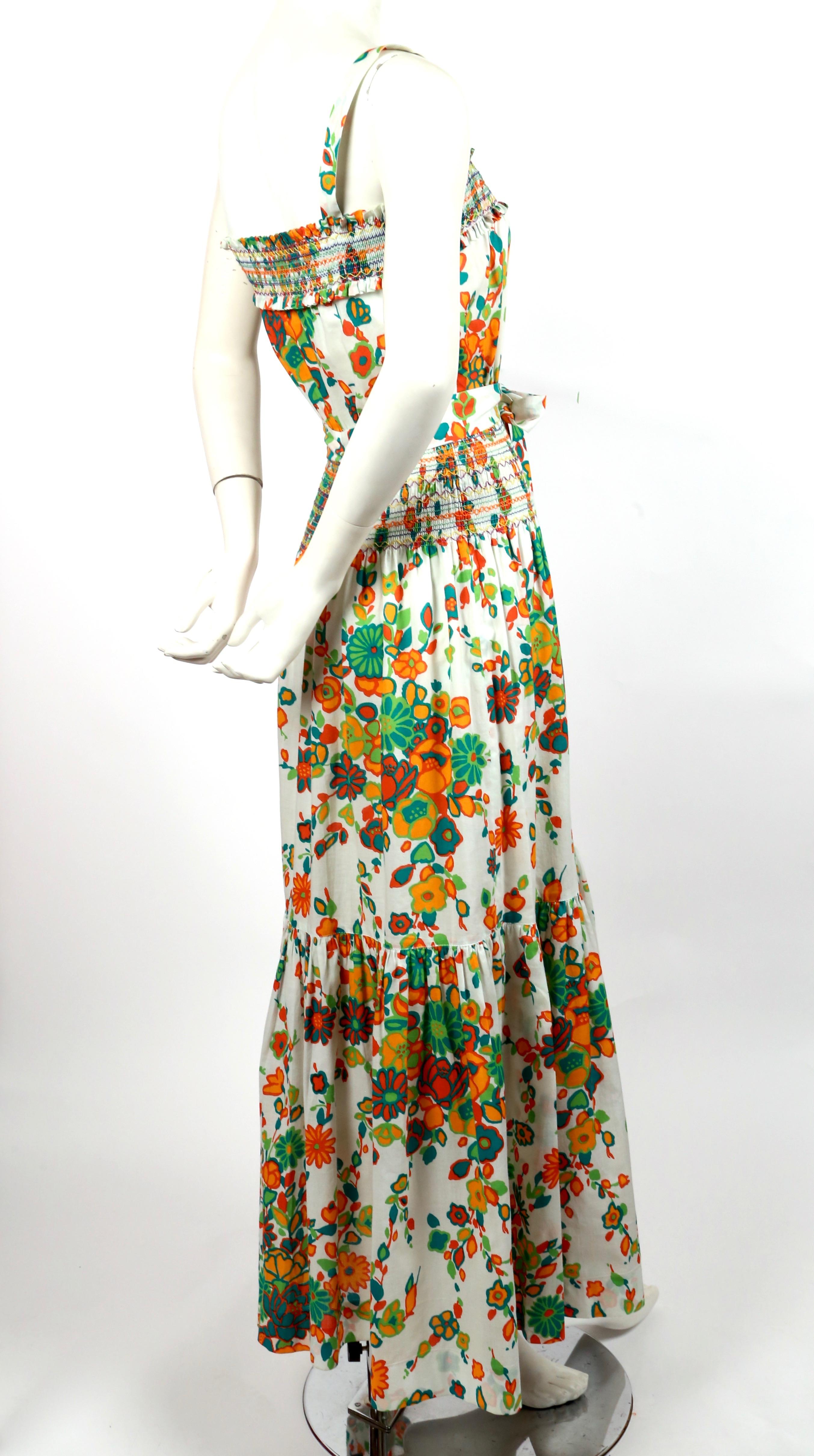 Very rare, white, cotton, floral printed dress with multi-colored hand-stitching and long waist tie from Yves Saint Laurent dating to the 1970's. Labeled a French size 36. Approximate measurements: up to a 33