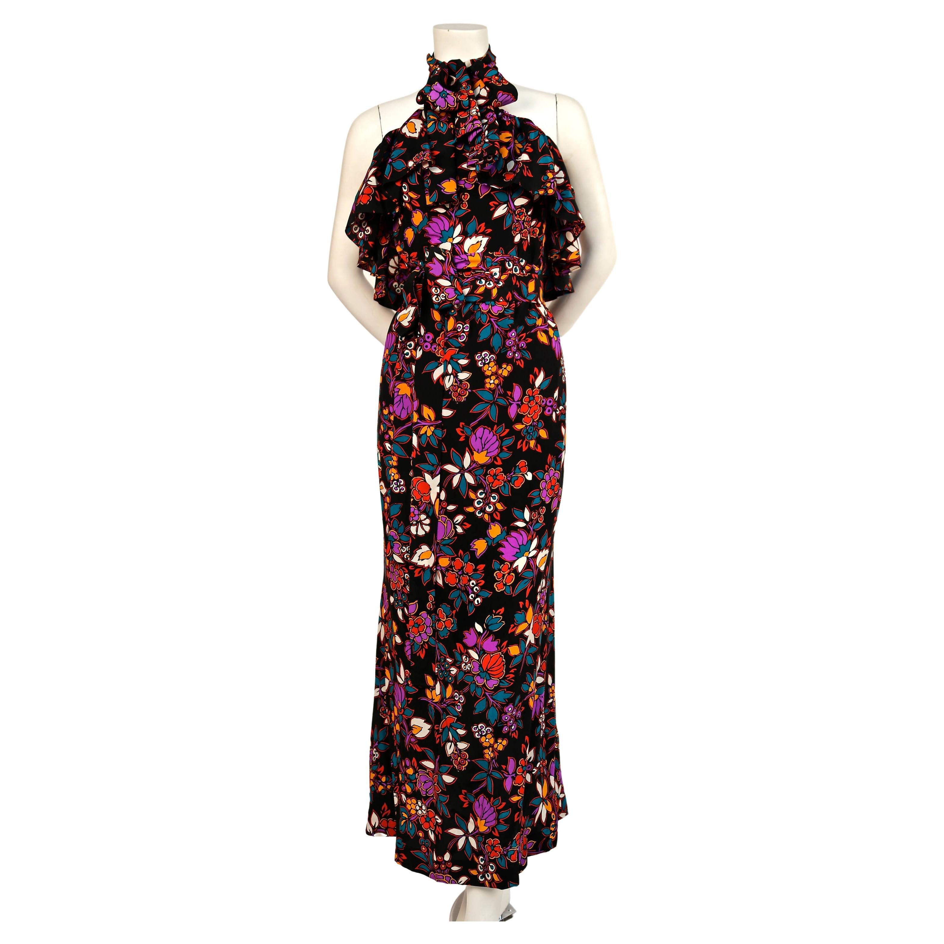 Very rare, black floral printed silk dress with halter neck, flounce at bust and matching long sash from Yves Saint Laurent dating to the late 1970's. Halter neck can be tied at back of neck or worn with a bow in front. Labeled a French size 40