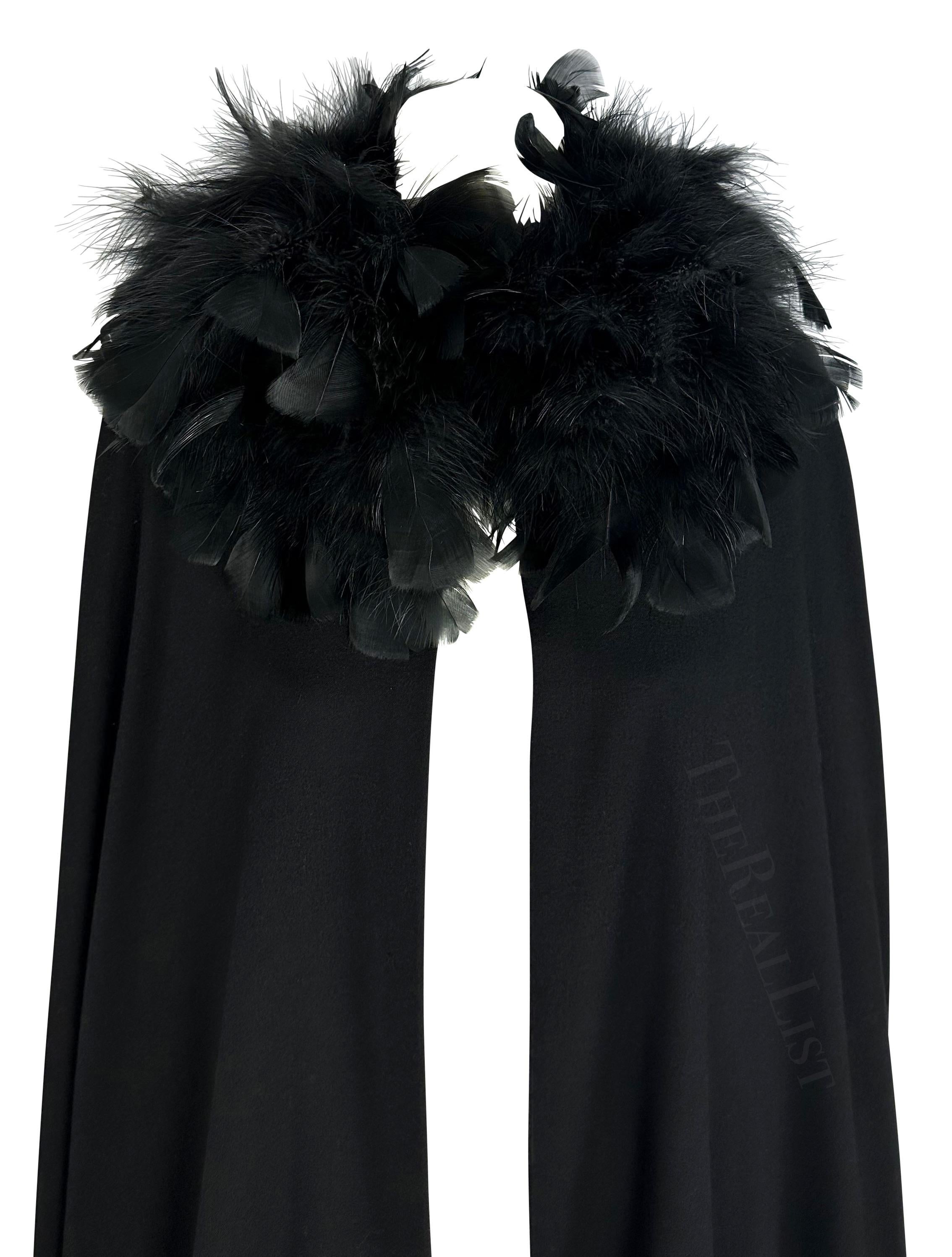 Presenting a gorgeous black Yves Saint Laurent haute couture cape, designed by Yves Saint Laurent. From the 1970s, this floor-length wool cape beautifully drapes off the shoulder. Adorned with voluminous black feathers at the neckline, this handmade