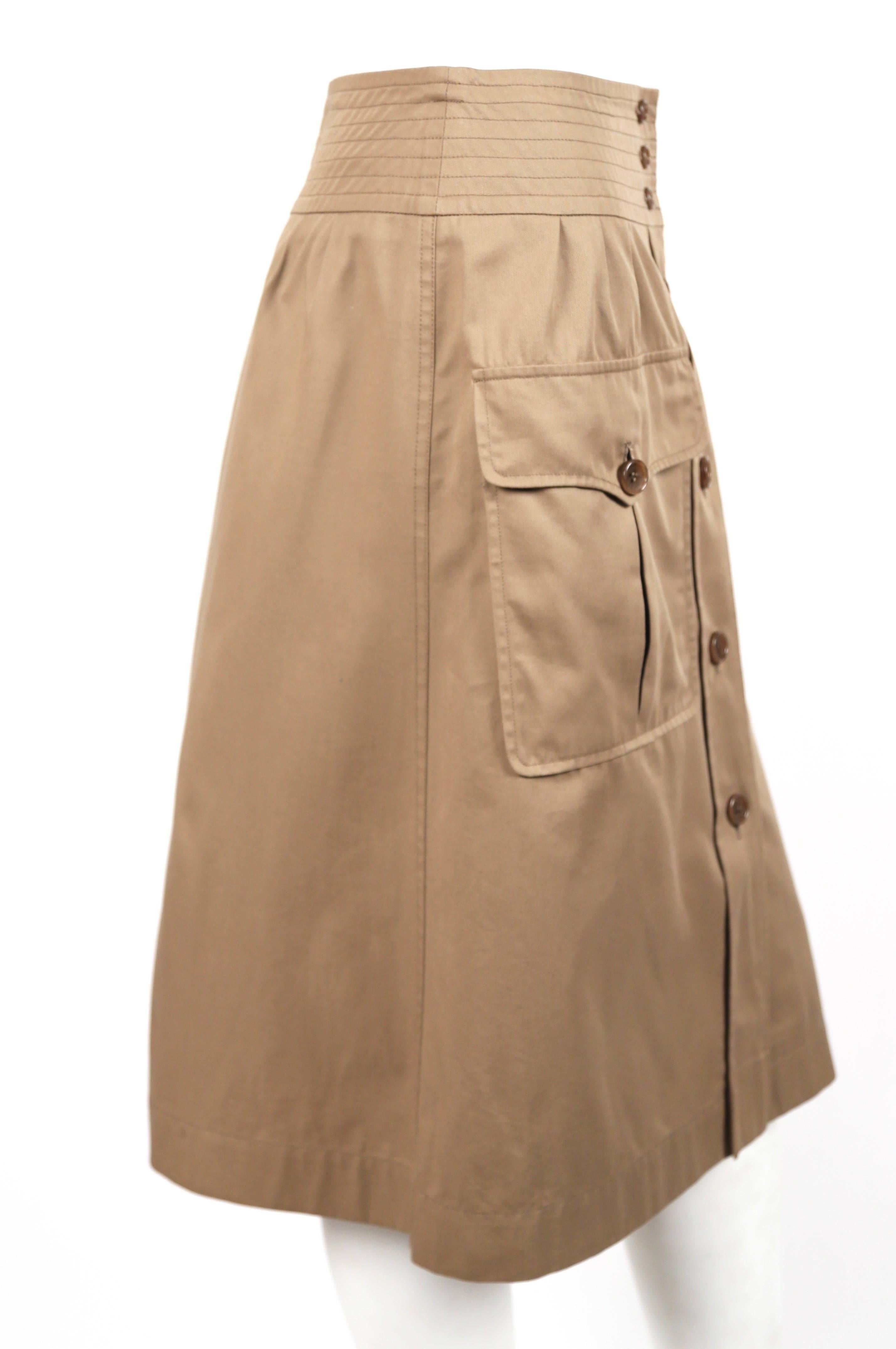 Khaki cotton safari skirt with A-line shape designed by Yves Saint Laurent dating to the 1970's. French size 40. Approximate measurements: waist 26