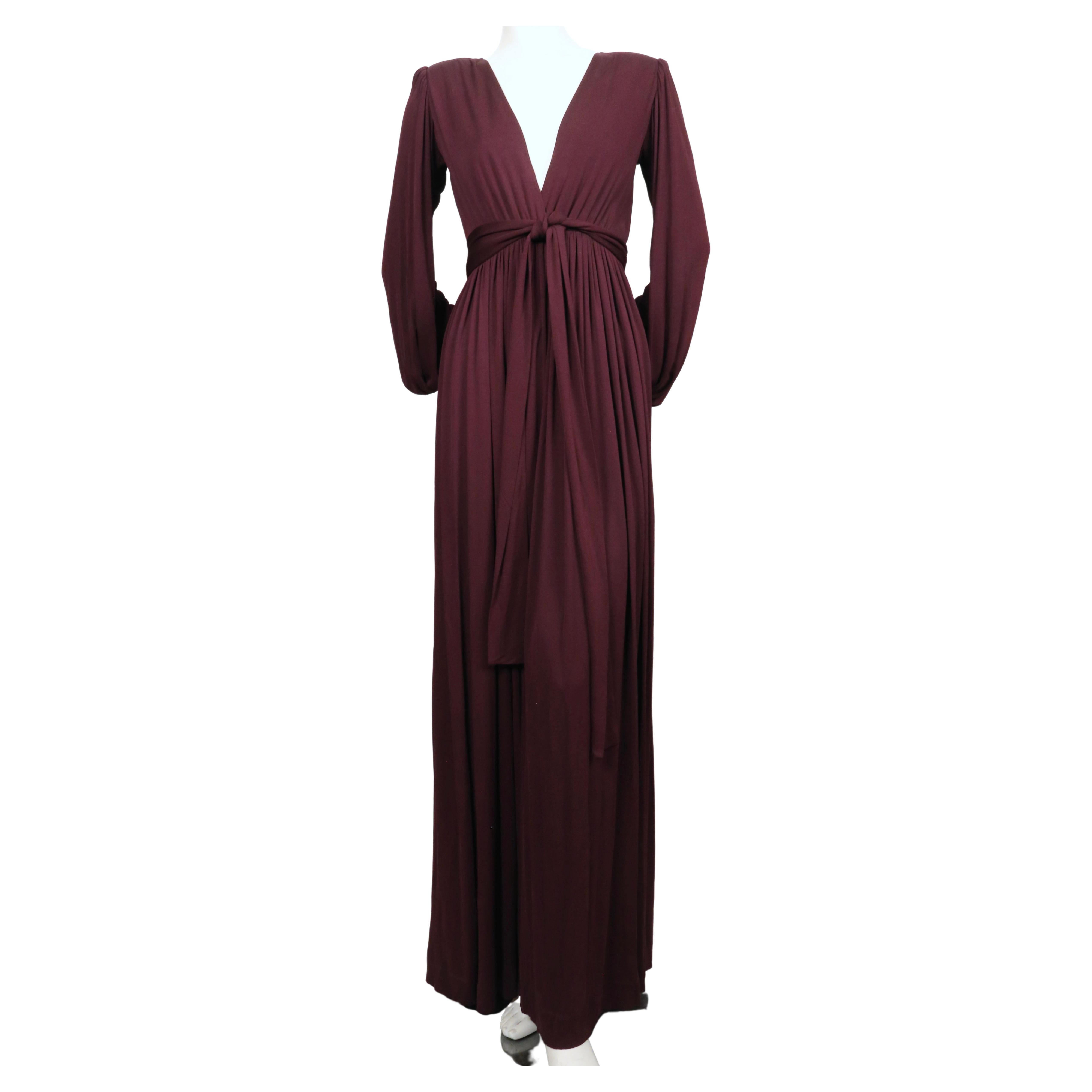 Exceptional, deep-plum jersey gown with deep V neckline, billowy sleeves and wrap belt from Yves Saint Laurent dating to the late 1970's. Labeled a French size 36