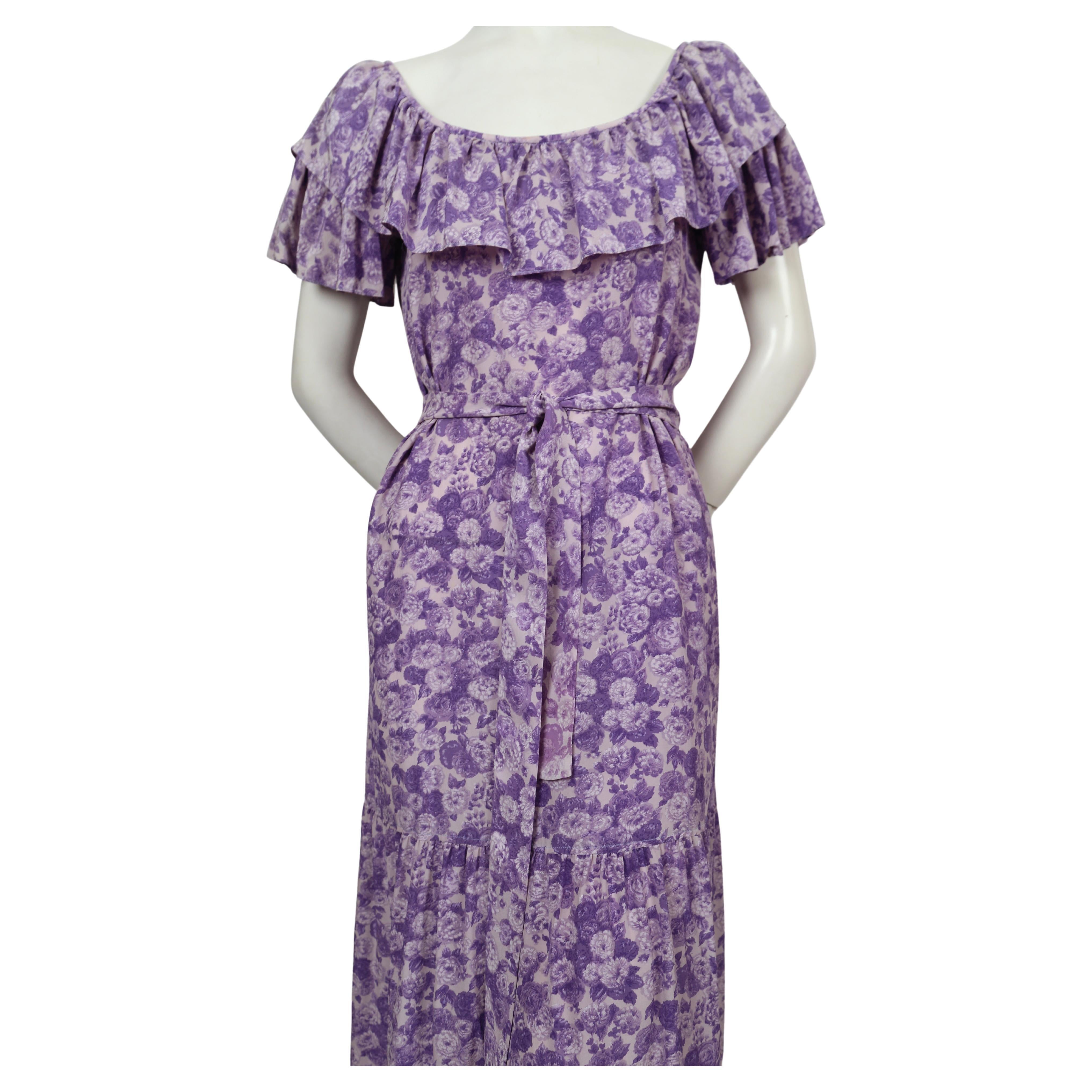 Robe en soie violette, imprimée de fleurs, avec un long lien à la taille, d'Yves Saint Laurent, datant des années 1970. Labellisé en taille 42, il est cependant très petit, surtout s'il est porté sur les épaules. Mesures approximatives : jusqu'à 35