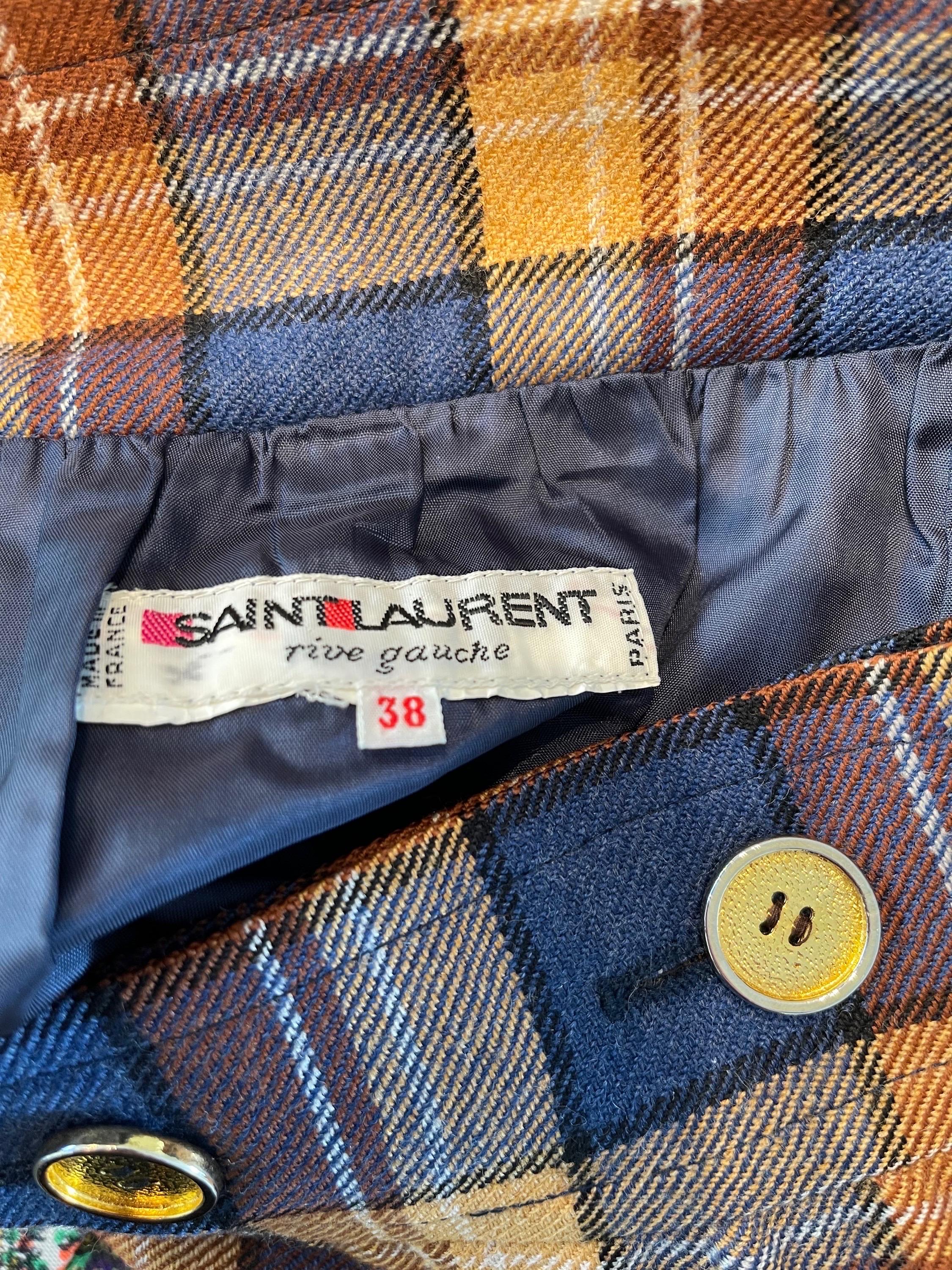 Chic 1970s YVES SAINT LAURNT Rive Gauche plaid wool skirt ! This YSL skirt has warm hues of navy blue, nude, tan and brown. Gold buttons down the front. Lightweight wool ; fully lined. Would look great with brown boots.
In great condition 
Made in