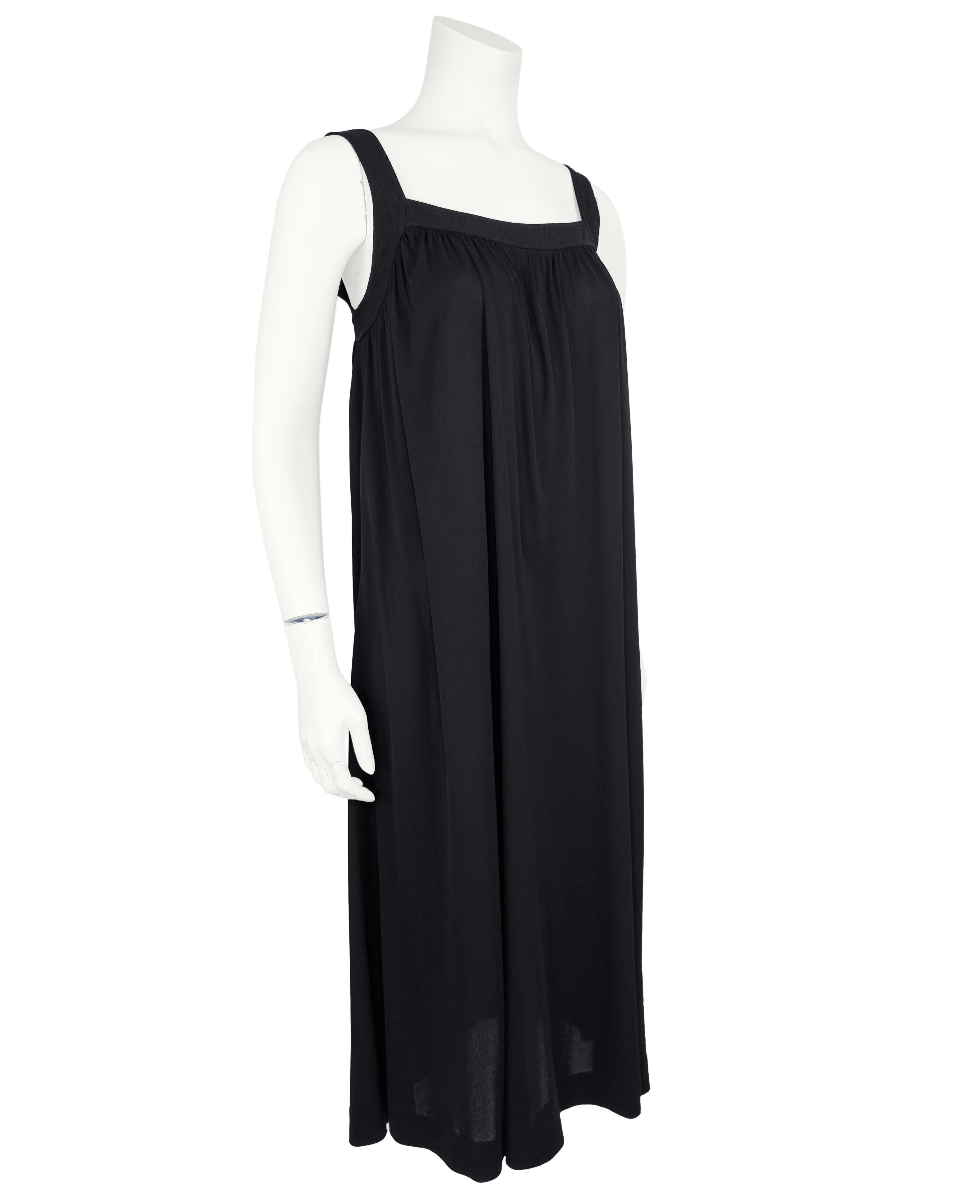Effortless elegance meets timeless sophistication in this 1970s Yves Saint Laurent black maxi dress. Designed with a refined square neckline and 1