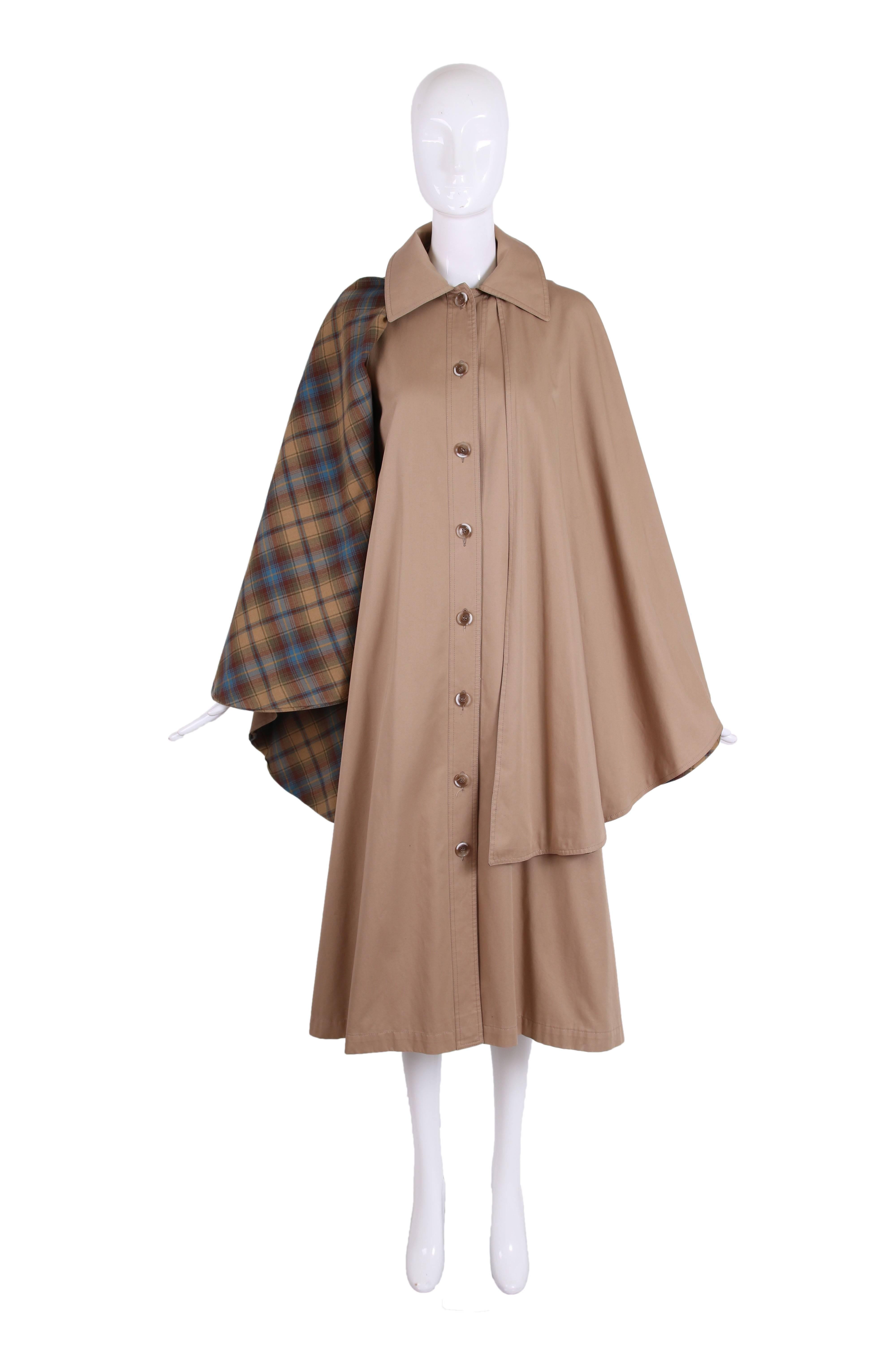 1970's Yves Saint Laurent khaki cotton cape coat with plaid interior, button closure down center front and side vents at hem. In excellent condition with a very small dark mark at front located next to side vent at hem. No size tag so please consult
