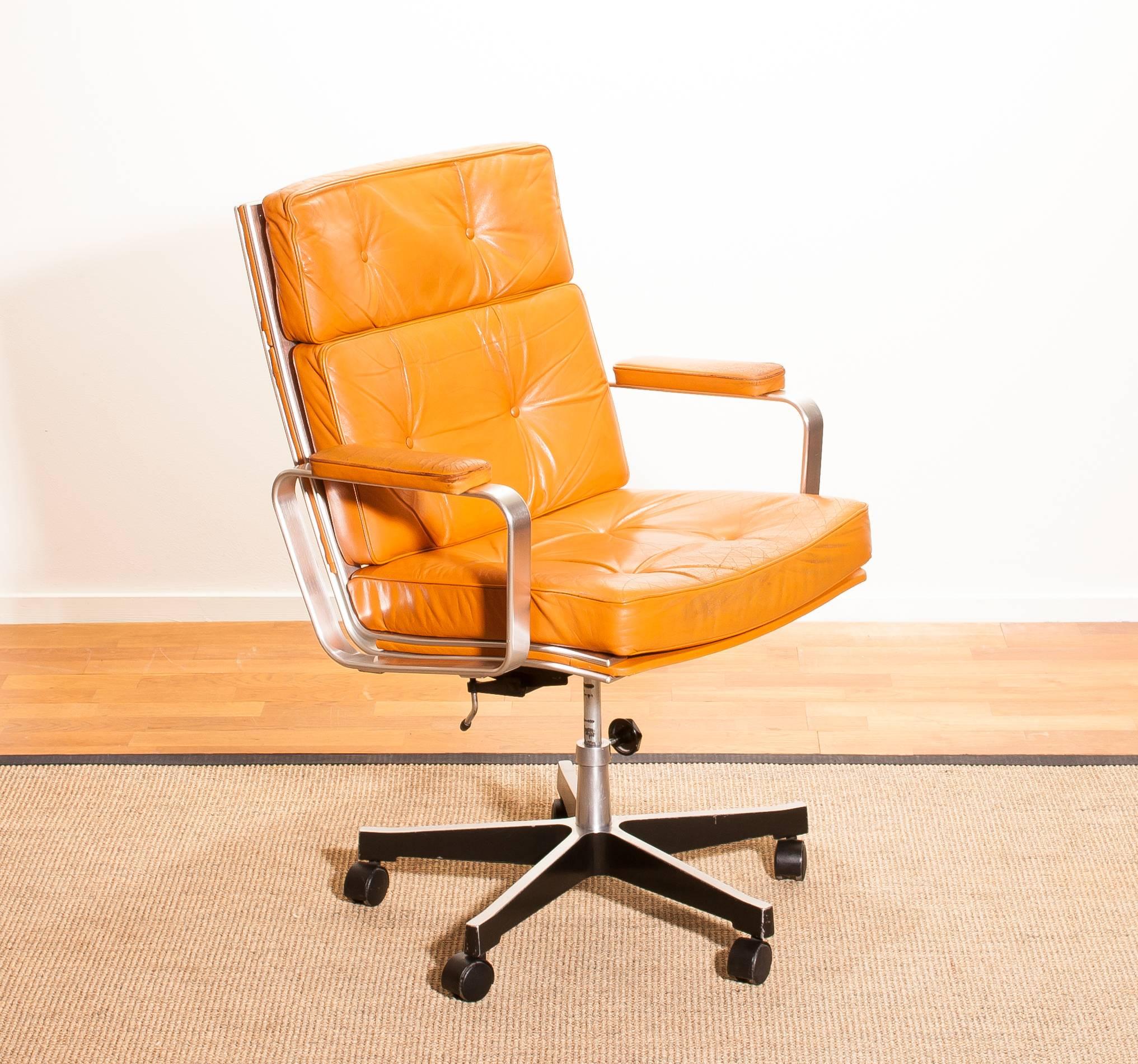 Beautiful adjustable office chair designed by Karl Erik Ekselius for JOC Möbler.
The nice thick solid cognac leather with an aluminium frame and steel five legs on wheels is a very nice combination.
The chair is very comfortable. 
It is in a very