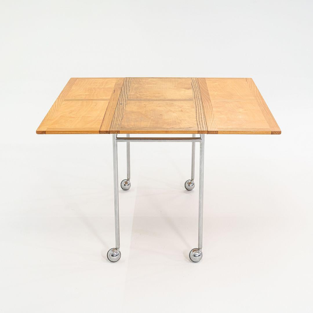 Il s'agit d'une table roulante Berit, conçue par Bruno Mathsson et produite par Firma Karl Mathsson en Suède. Le chariot date de 1971 et porte le logo du fabricant sur le fond. Son plateau est fabriqué à la fois en frêne et en bouleau, et sa base en