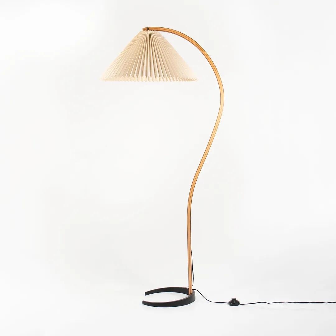 This is an iconic Danish Timberline / Caprani floor lamp, designed by Mads Caprani in Denmark in 1971. The lamp's design features a sculptural curved bent-beech stand with teak veneer, and has a cast-iron demilune footed base. Most importantly, it