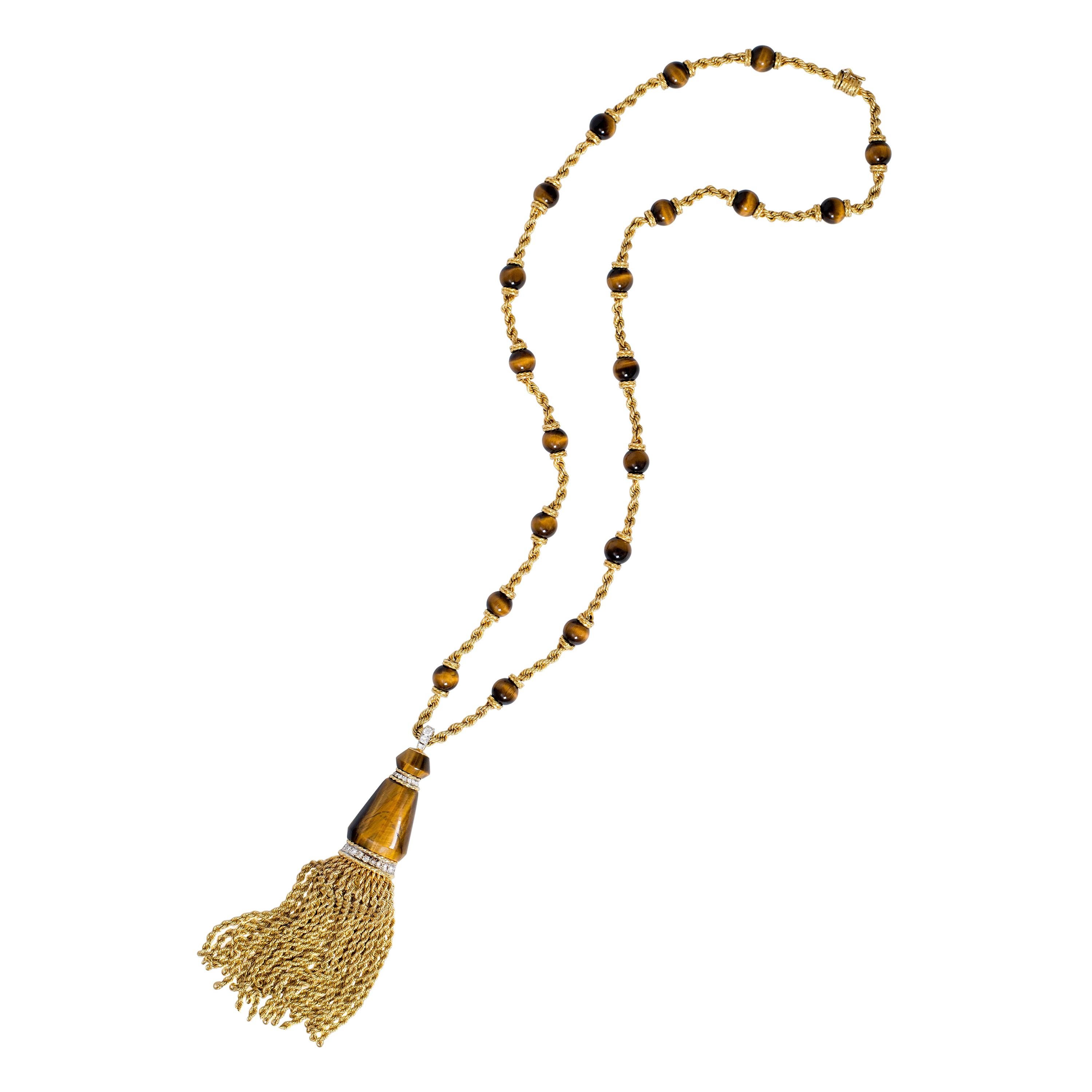 A tiger's eye, diamond and 18 karat gold braided tassel sautoir, by British jewelry house of Kutchinsky, 1971.  

The pendant is signed Kutchinsky, stamped with maker's mark K LD, London hallmarks dated with the letter 