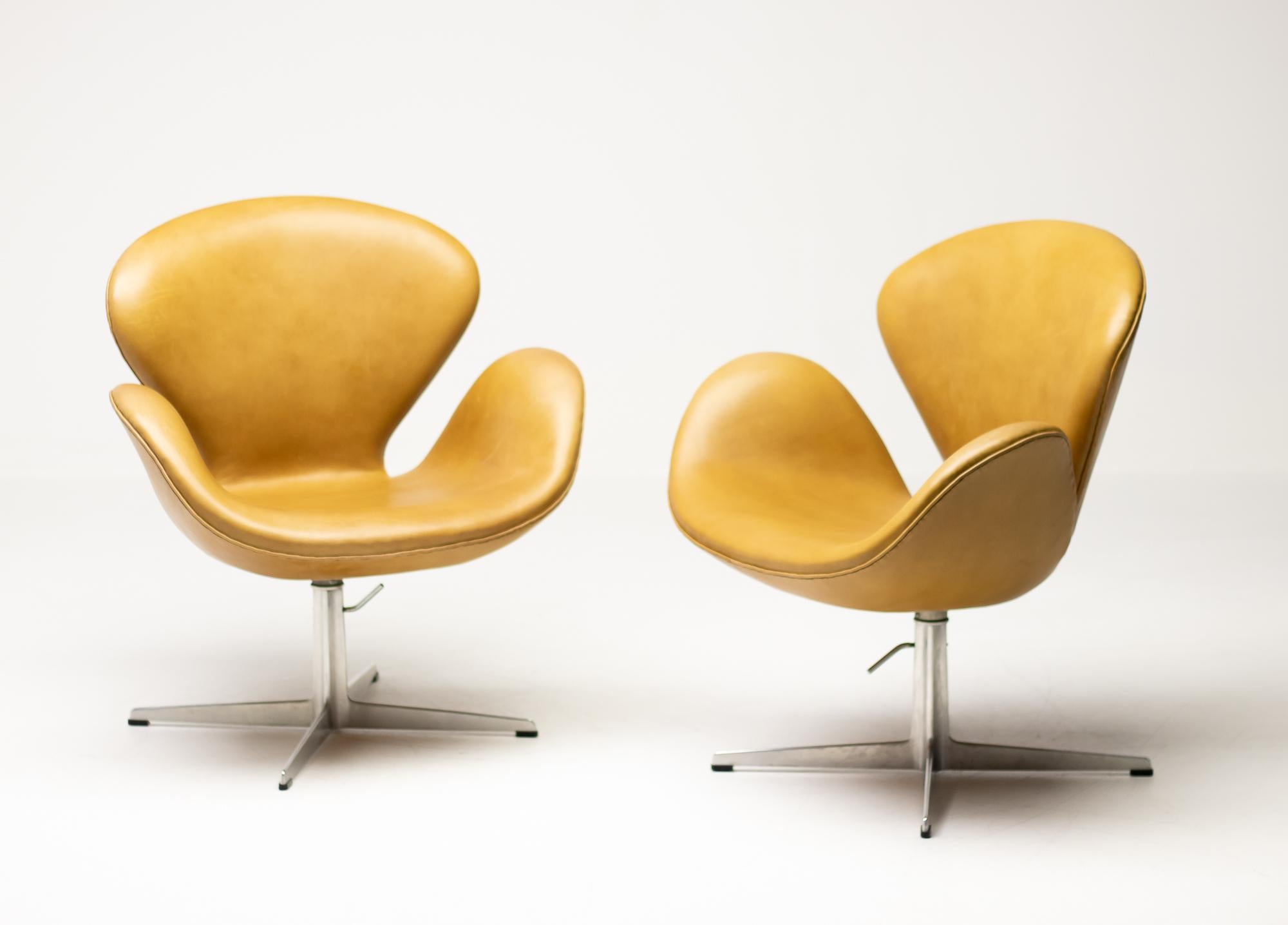 Matching pair of Swan Chairs in beautiful light brown natural leather. 
The chairs have the very rare option of height adjustability, so you could use them as a desk or dining chair as well.
Reupholstered in Denmark circa 8 years ago with new foam