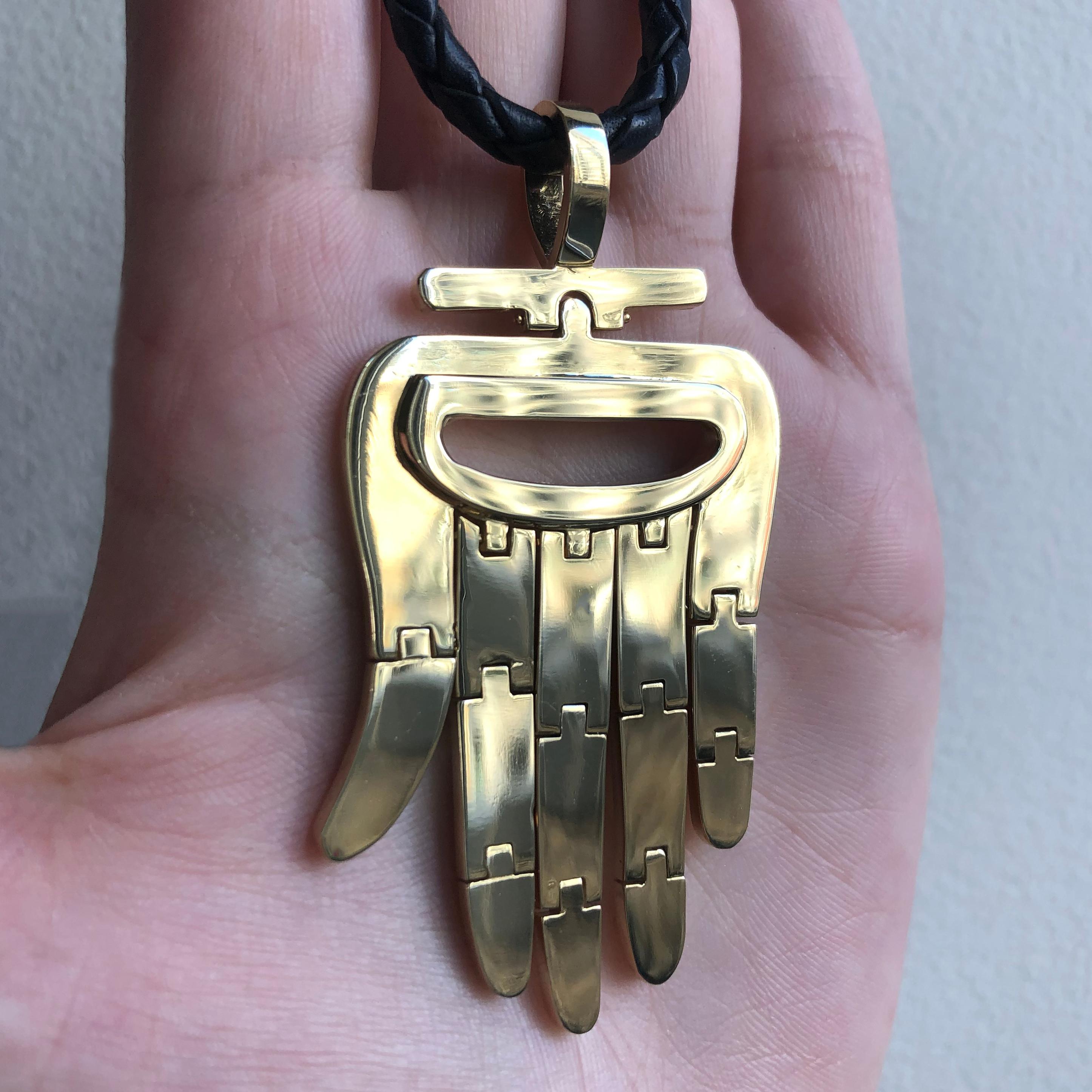 An iconic 18 karat gold flexible Hamsa pendant, by Aldo Cipullo, 1972. 

The pendant is signed A. Cipullo. Stamped 18k, copyright symbol and dated 1972. 
