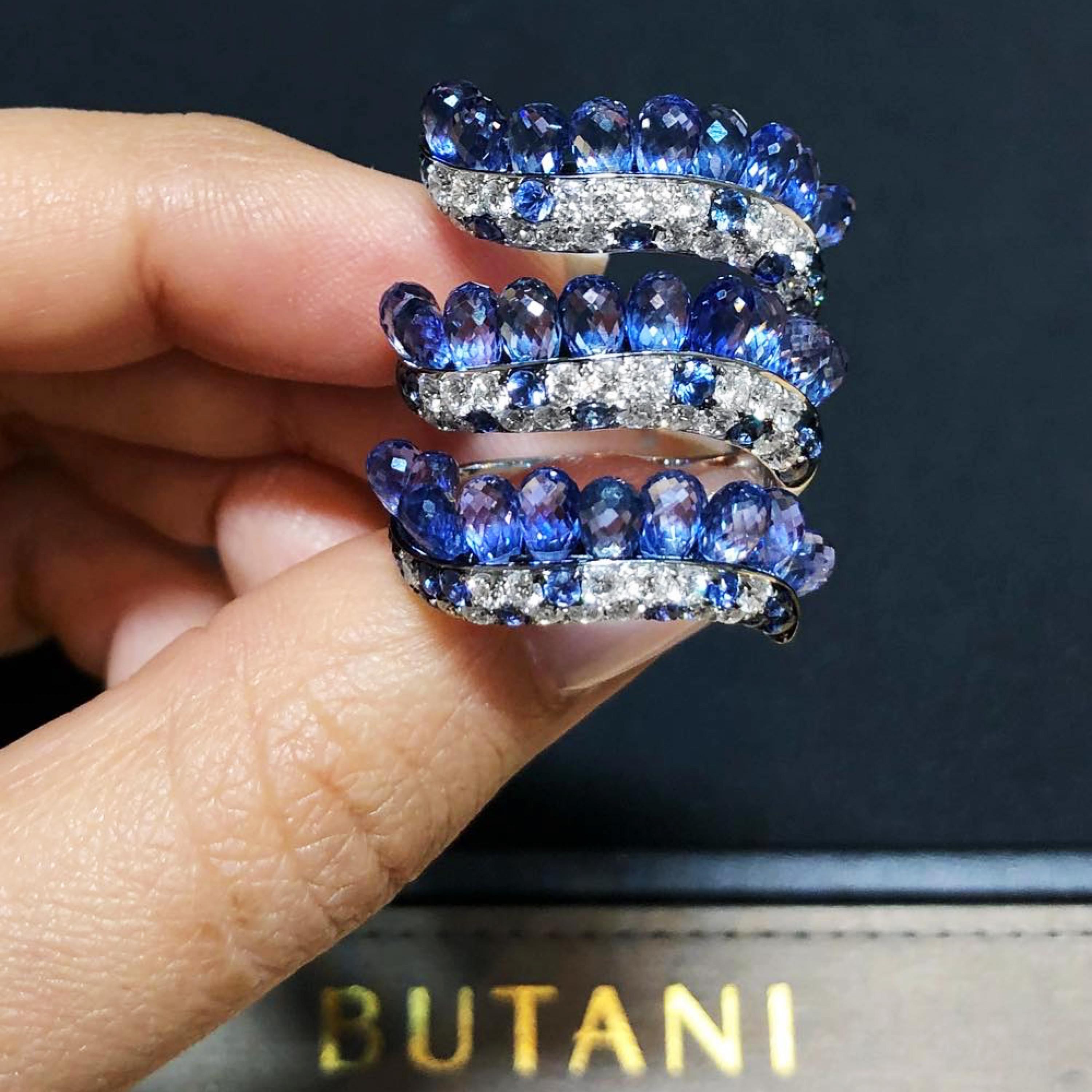 Featuring a wrap silhouette, Butani's 18-karat white gold ring is encrusted with 16.7 carats of blue sapphire briolettes.  These eye-catching gemstones are delicately set as though they are floating drops in a sea of white diamonds (totaling 1.69