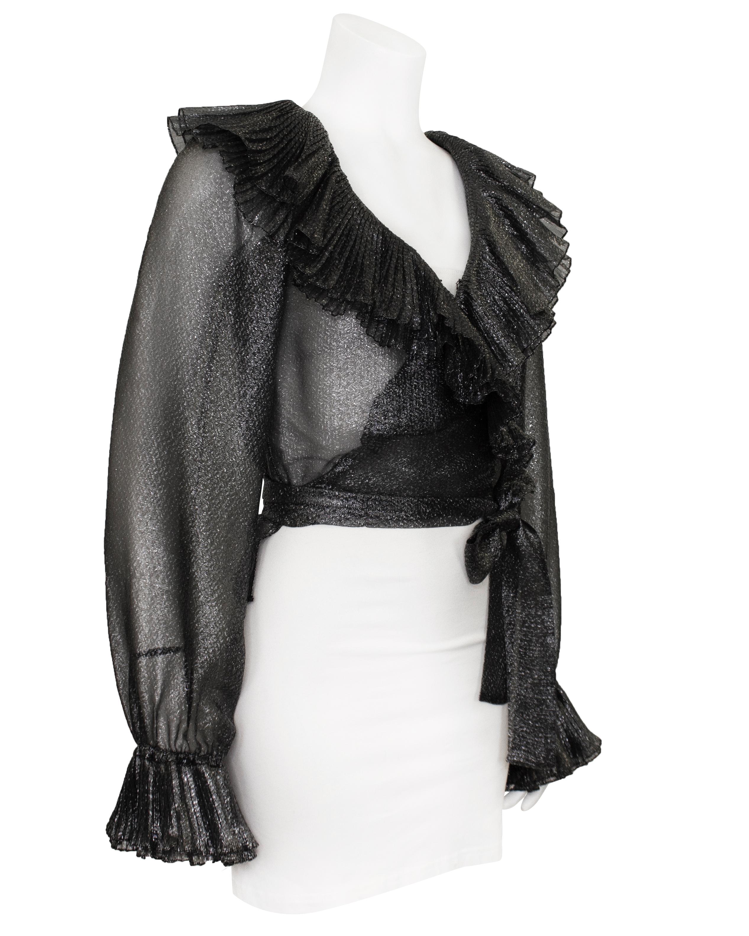 Indossata nella sfilata Saint Laurent Autunno/Inverno del 1972, questa bellissima blusa da sera si abbina perfettamente a una gonna o a un pantalone. Realizzato in tessuto lurex argento trasparente e scintillante, con doppio risvolto a micro pieghe,