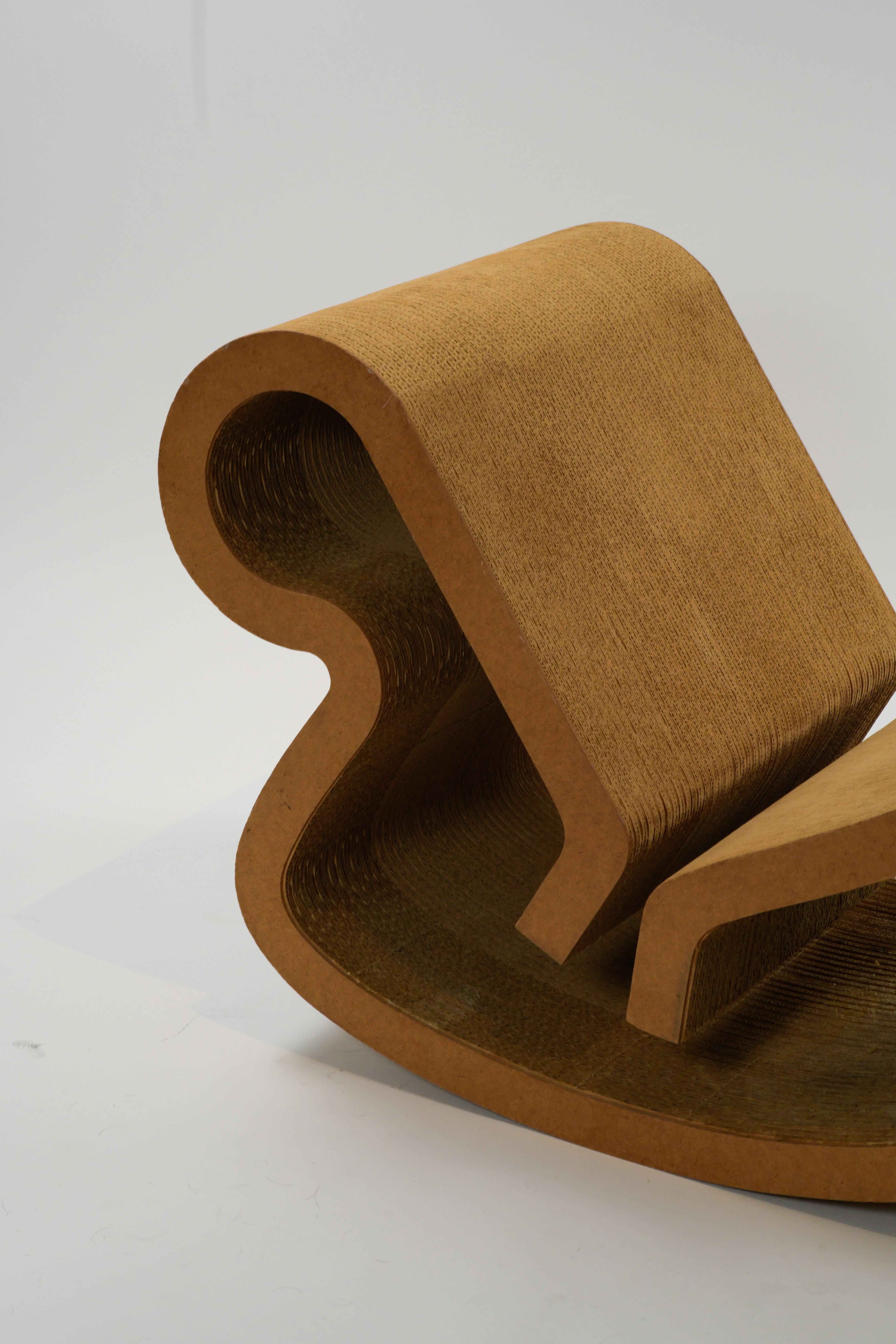 Chaise longue à bascule 'Contour' iconique des années 1970, réalisée par le célèbre architecte Frank Gehry pour Easy Edges, Inc. Cette magnifique chaise de salon patinée est faite de carton ondulé laminé et de masonite et est en très bon état compte