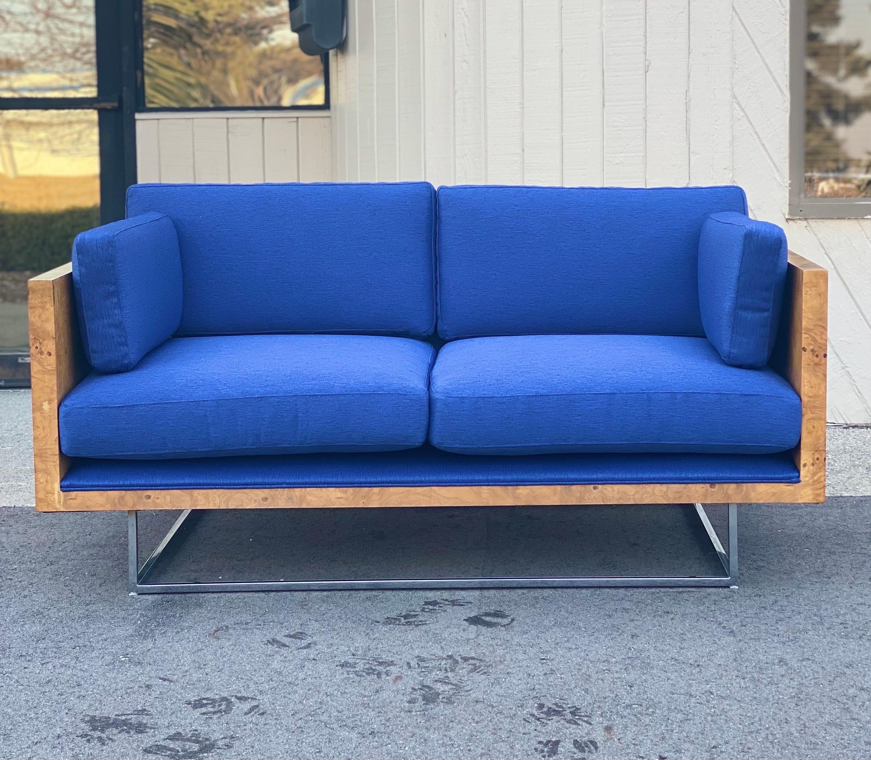 We are very pleased to offer a pair of case study sofas by Milo Baughman for Thayer Coggin, circa 1972. This stunning pair showcases a burl wood case and a chrome base that gives the illusion of a floating seat. A savvy statement pair for elevating