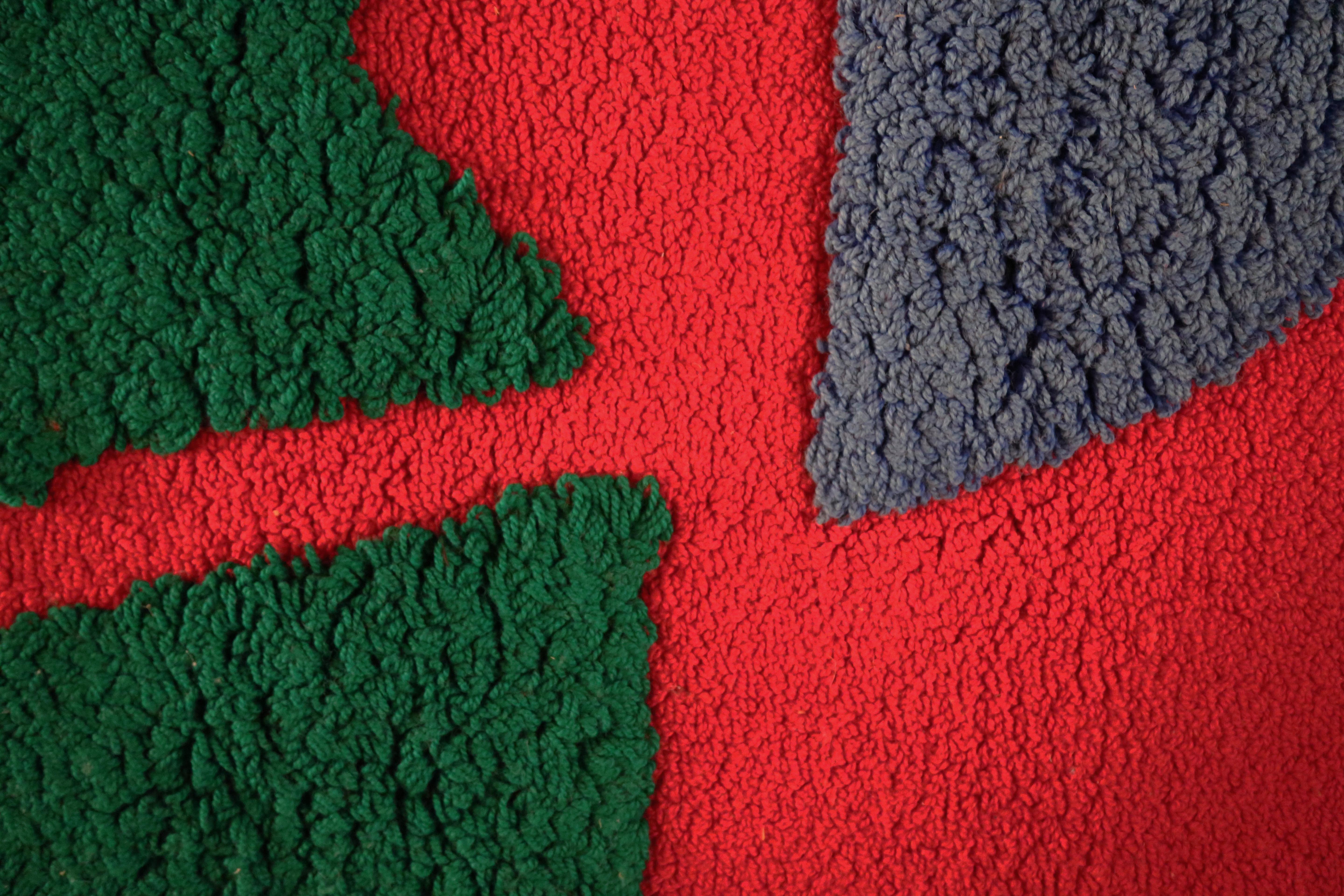 Fabriqué à la main dans le studio de l'artiste Harry Harris en 1973, à partir de 100 % de laine vierge importée. Fils crochetés et bouclés dans un motif texturé audacieux. De la collection personnelle de Harry Harris. Un rouge vif stupéfiant avec du