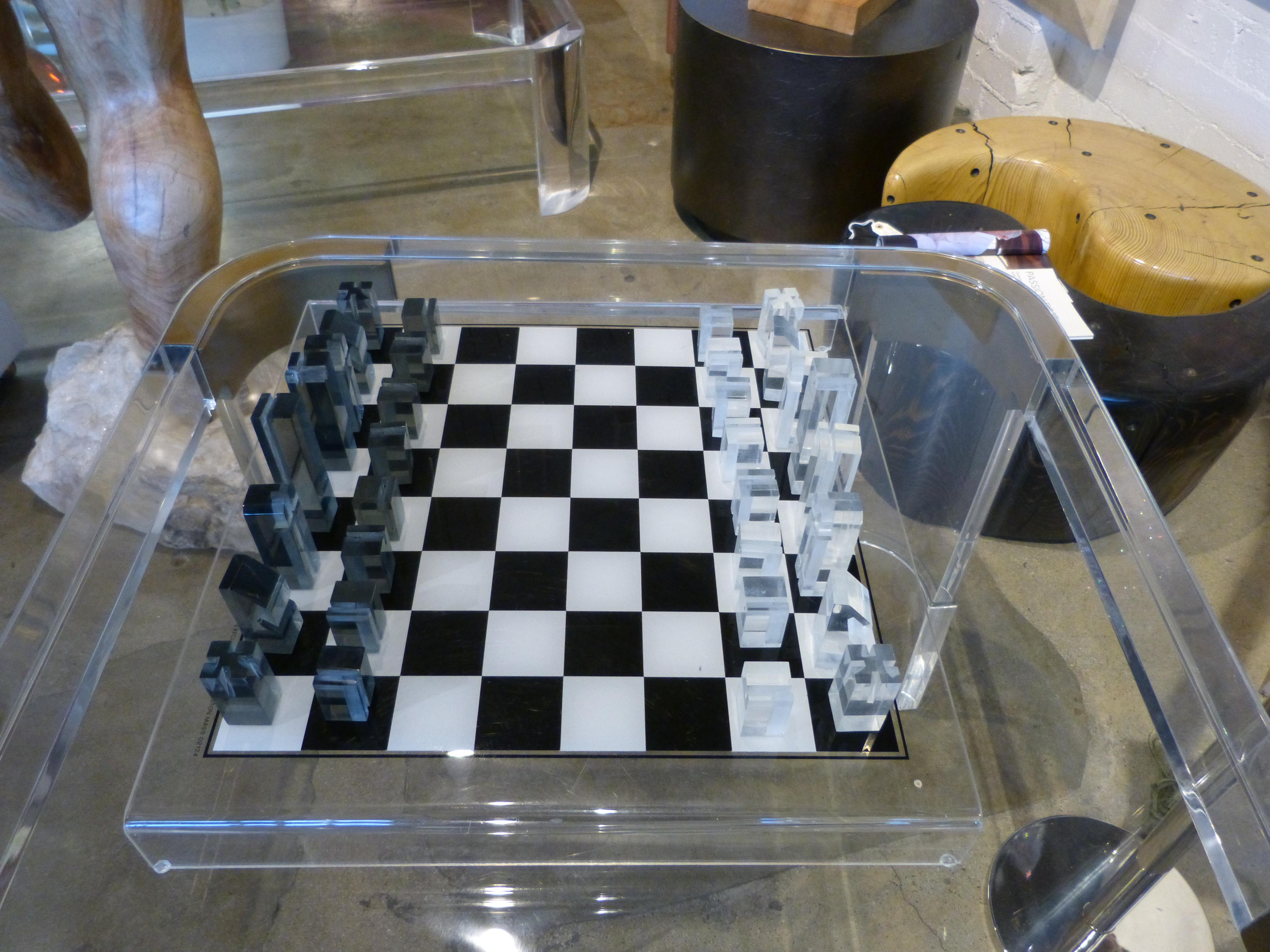 A nice raised acrylic chess board with light and dark chess pieces. It is marked 1973 Executive Games inc, Boston Mass. There is a bit of marks to the board the worst of which are pictured. The chess pieces also have some age appropriate wear. the