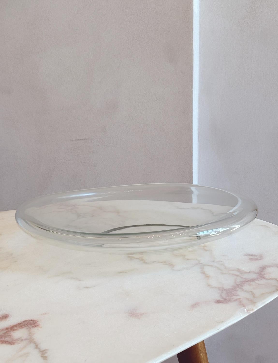 Un eccezionale centrotavola in vetro di Murano soffiato a mano firmato Vistosi. Questa splendida ciotola ha un bordo curvo rialzato ed è interamente cava. Ci sono occasionalmente piccole bolle d'aria che testimoniano la sua natura soffiata a mano. È