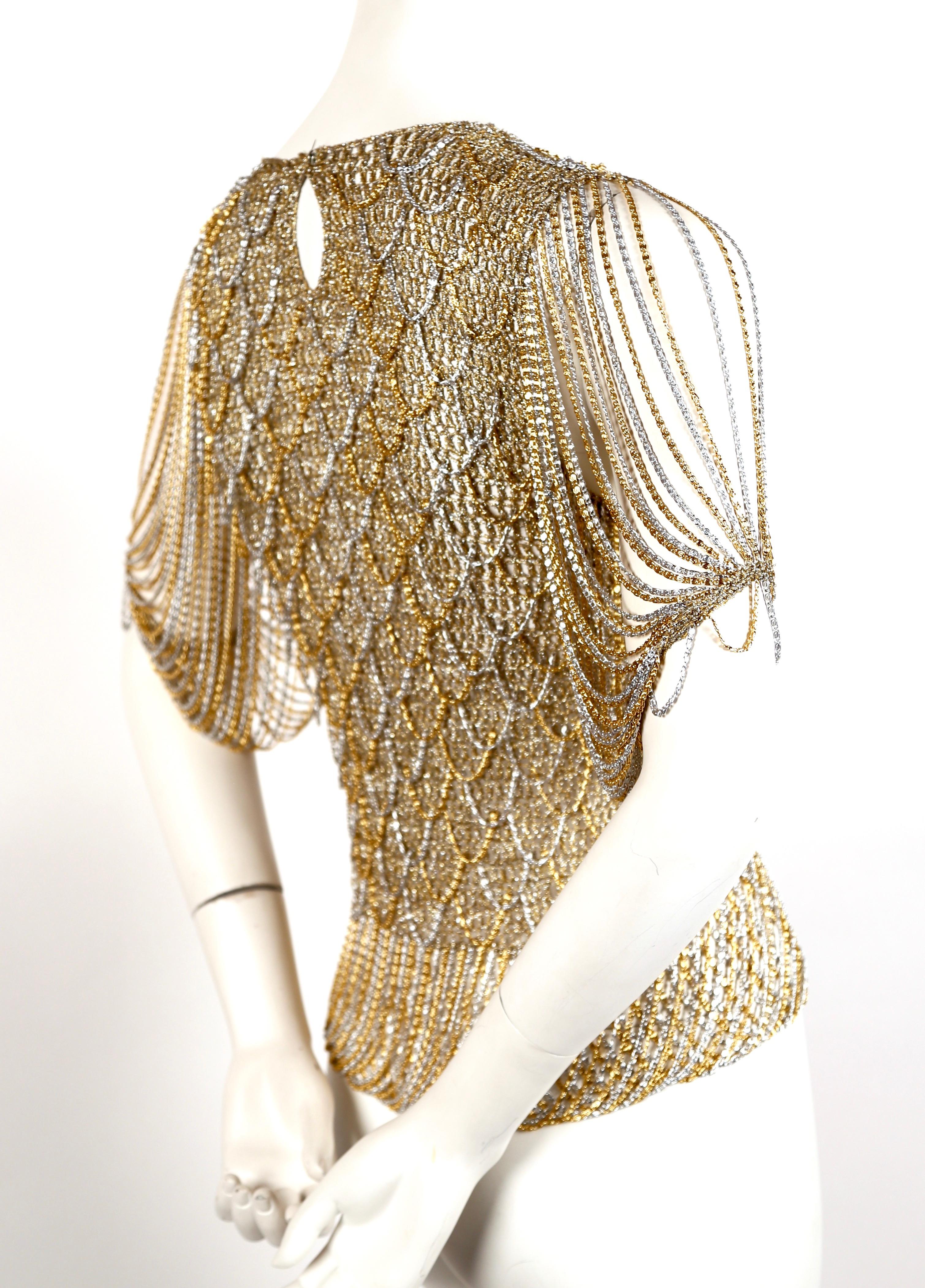 Woven gold and silver metallic sweater intertwined with chain from Loris Azzaro dating to the 1973. Exact style sweater as seen in the Helmut Newton photograph. Fits a size XS or S. Approximate measurements (unstretched): 26