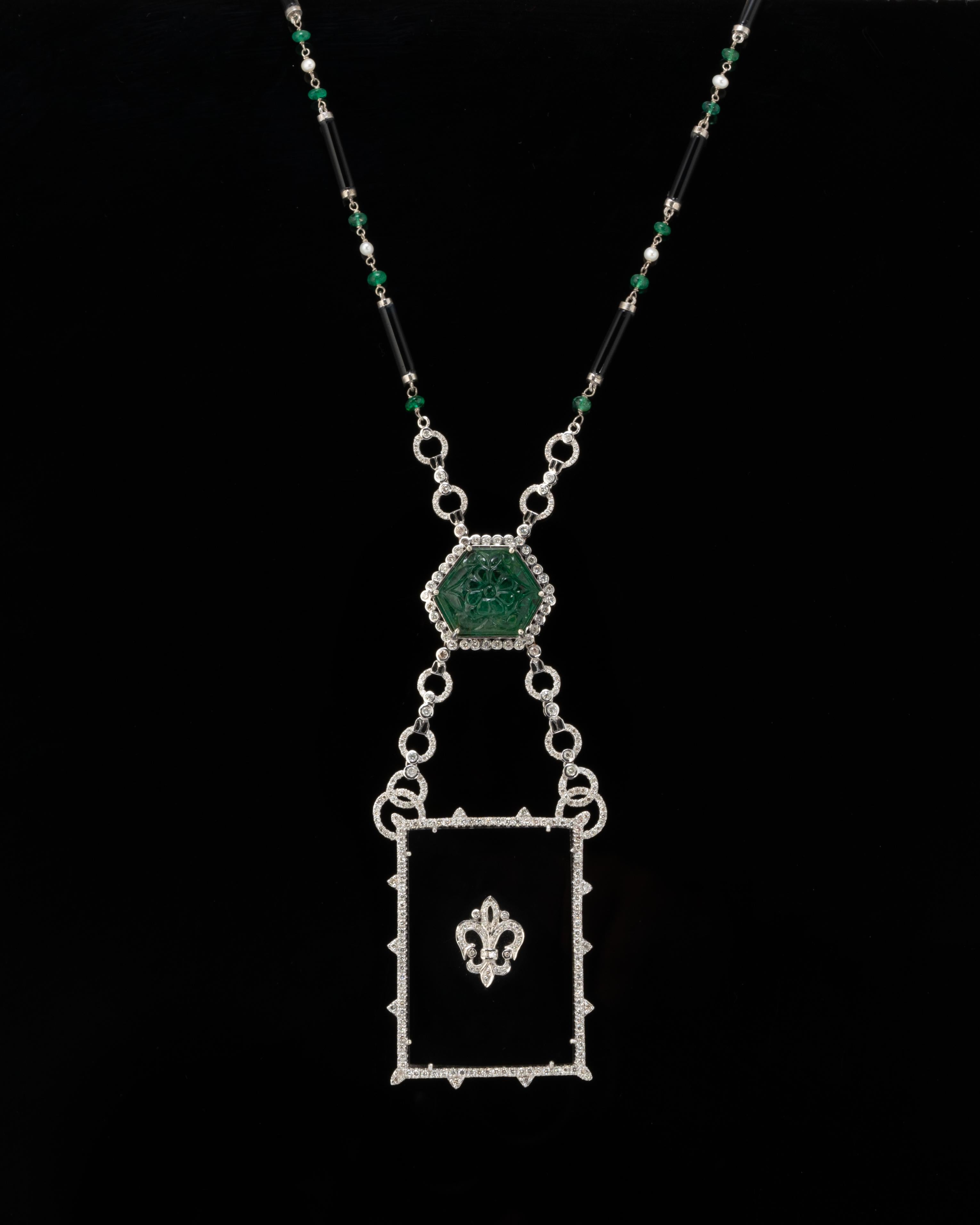 A very unique, art-deco 19.74 carat natural Zambian Emerald Carving and Black Onyx Necklace, with White Diamonds all set in 18K White Gold. The chain is 34 inches long, made using Zambian Emerald beads, Black Onyx and Diamonds. The length of the