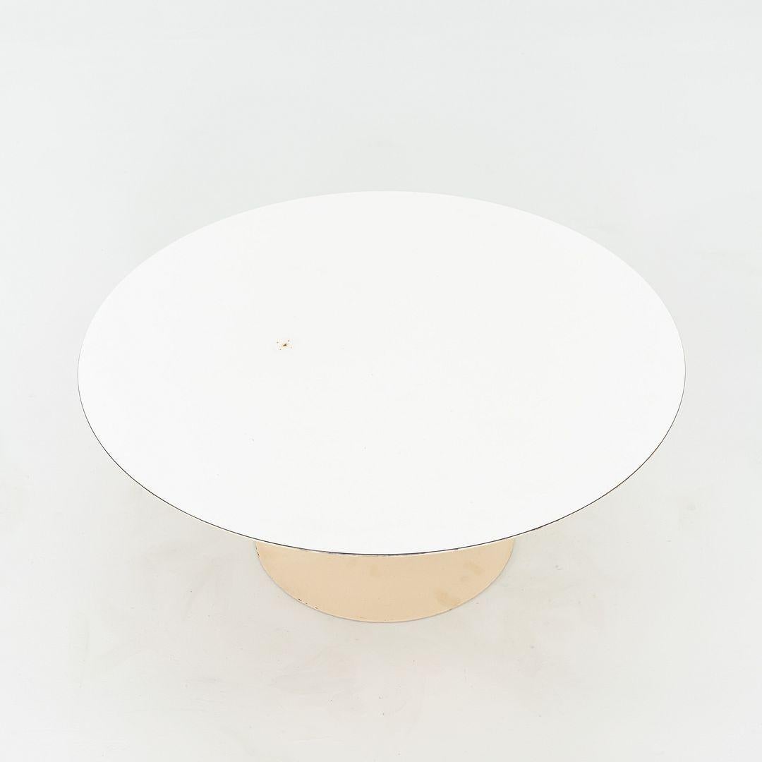 Il s'agit d'une table basse Saarinen, conçue à l'origine par Eero Saarinen en 1956. Cet exemplaire particulier a été produit par Knoll aux États-Unis en 1974. La table est composée d'une base en aluminium et d'un plateau en stratifié blanc. 
 
 La