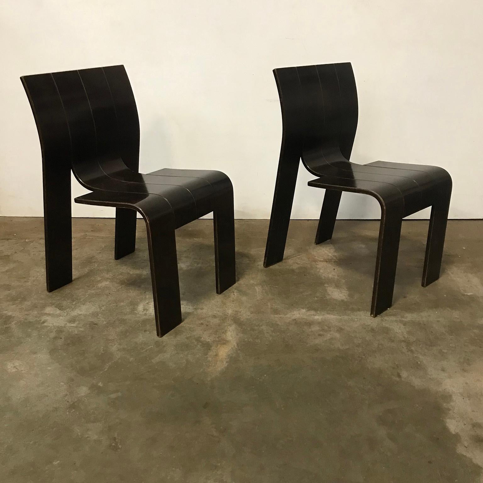 Two dark brown varnished stackable bended wood strip chairs. The chairs are beautiful and interesting because of the design. The condition is good although the chairs show some traces of wear like some loss of paint at the edges and some scratches