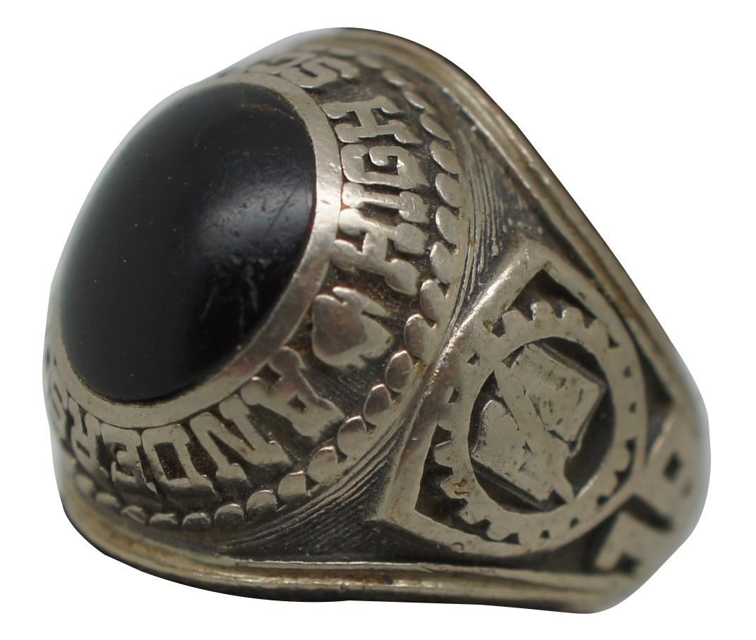 Vintage class of 1974 class ring from Anderson High School of Cincinnati, Ohio. Set with a rounded stone of matte black onyx, emblazoned on one side with the head of a Native American in front of a pair of crossed weapons and on the other with a