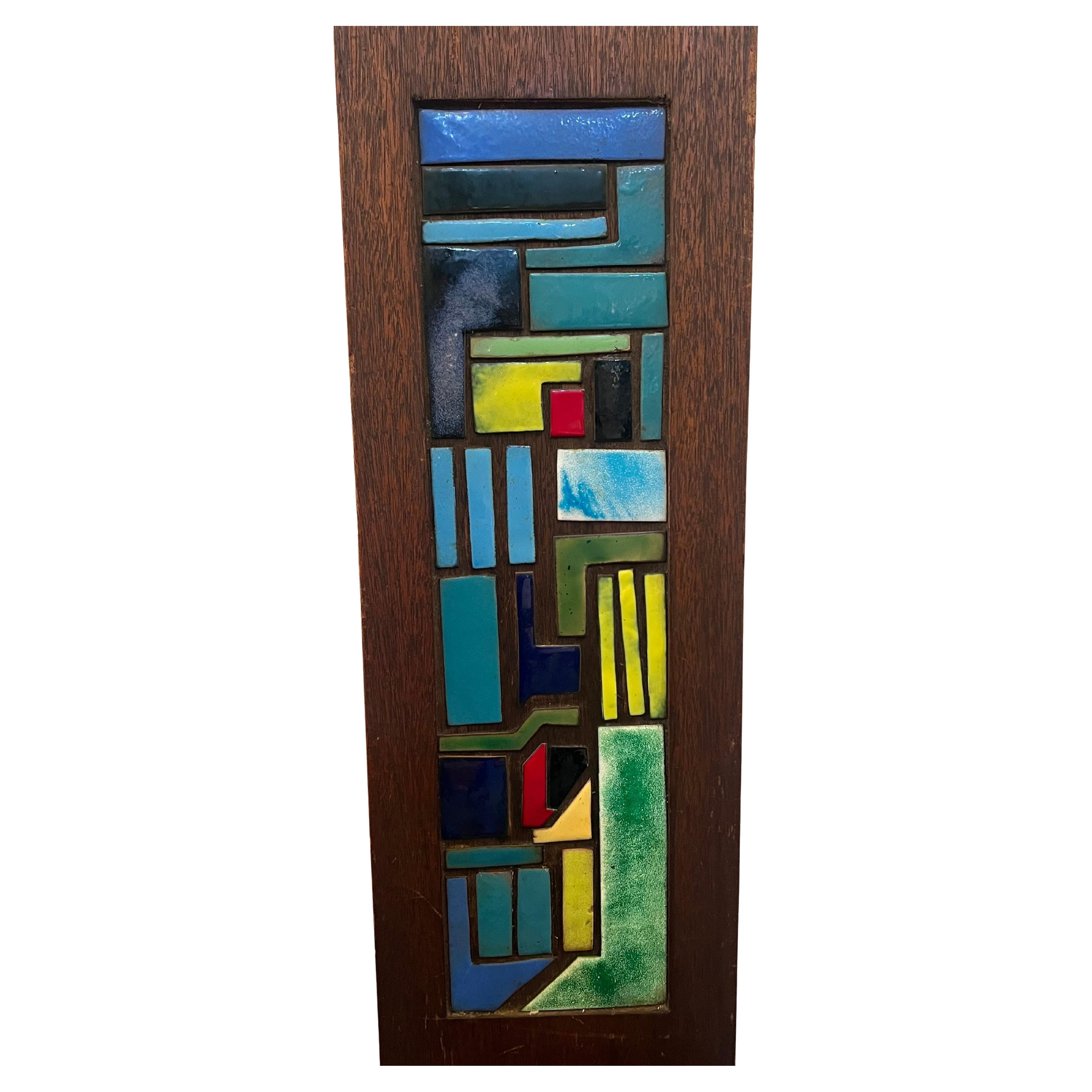 Preciosa placa mural abstracta única de esmalte sobre cobre de circa 1975 sin firmar, montada sobre listón de madera maciza de caoba fechada .