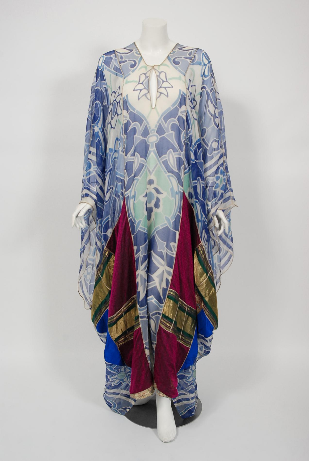 Gorgeous Thea Porter Couture bohemian abaya caftan dating back to the mid 1970's. This rare garment is fashioned in the most beautiful blue patterned silk chiffon (print possibly by Michael Szell) with colorful Damascus brocade patchwork. This