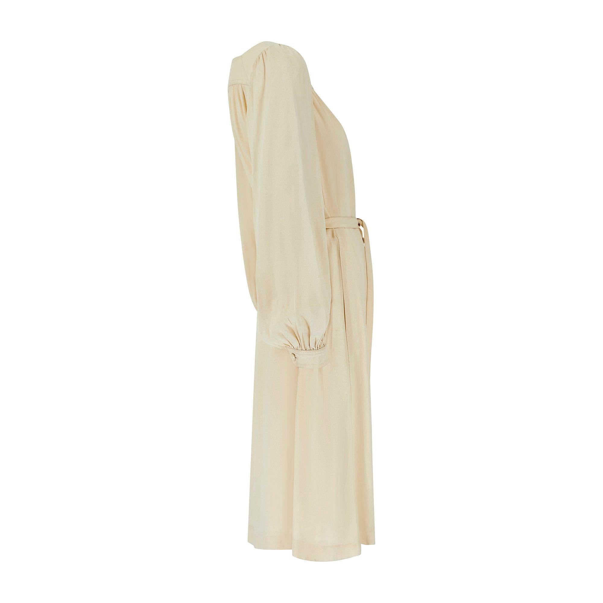 This elegant Yves Saint Laurent runway documented midi dress is from the spring 1975 collection and was a key design, featuring in both a cream and black version on the runway. Made in France, it is crafted from matte moss crepe in rich cream. The