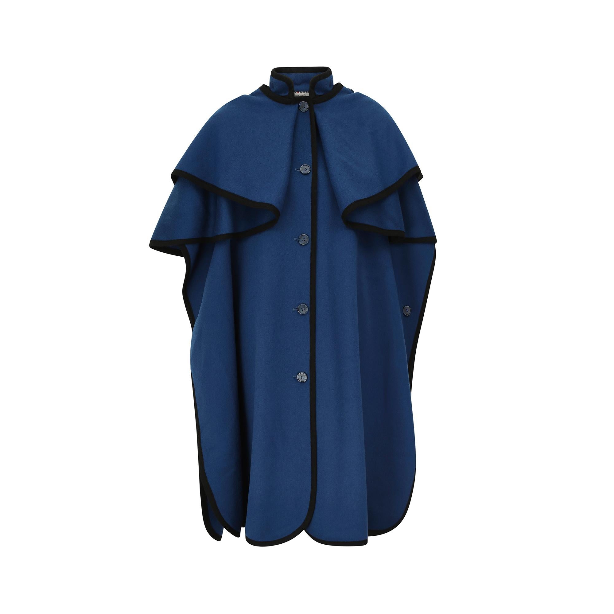 This magnificent A/W 1976 Yves Saint Laurent Rive Gauche peacock blue wool cape excites drama and style and can be worn two ways, varying the impact of the piece. The 100% soft wool felt is artfully fashioned to create a double tier tunic cape