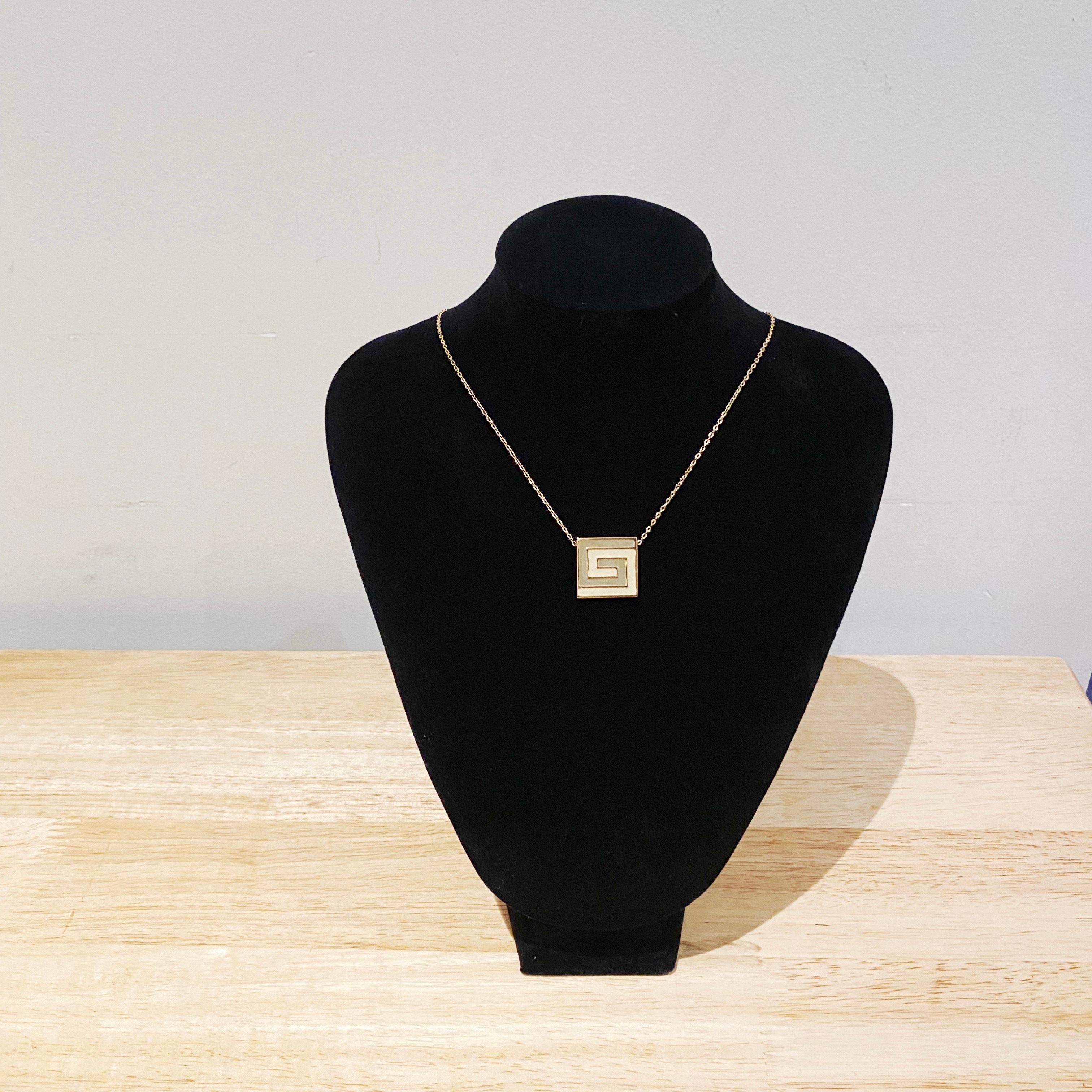 Circa, 1976
Signed: Givenchy 1976 New York Paris
Materials: Gold plating. Grey and cream enamel.
Size:39.5cm in length. Pendent 2cm x 2cm. Choker style. 
Condition: Good vintage condition.