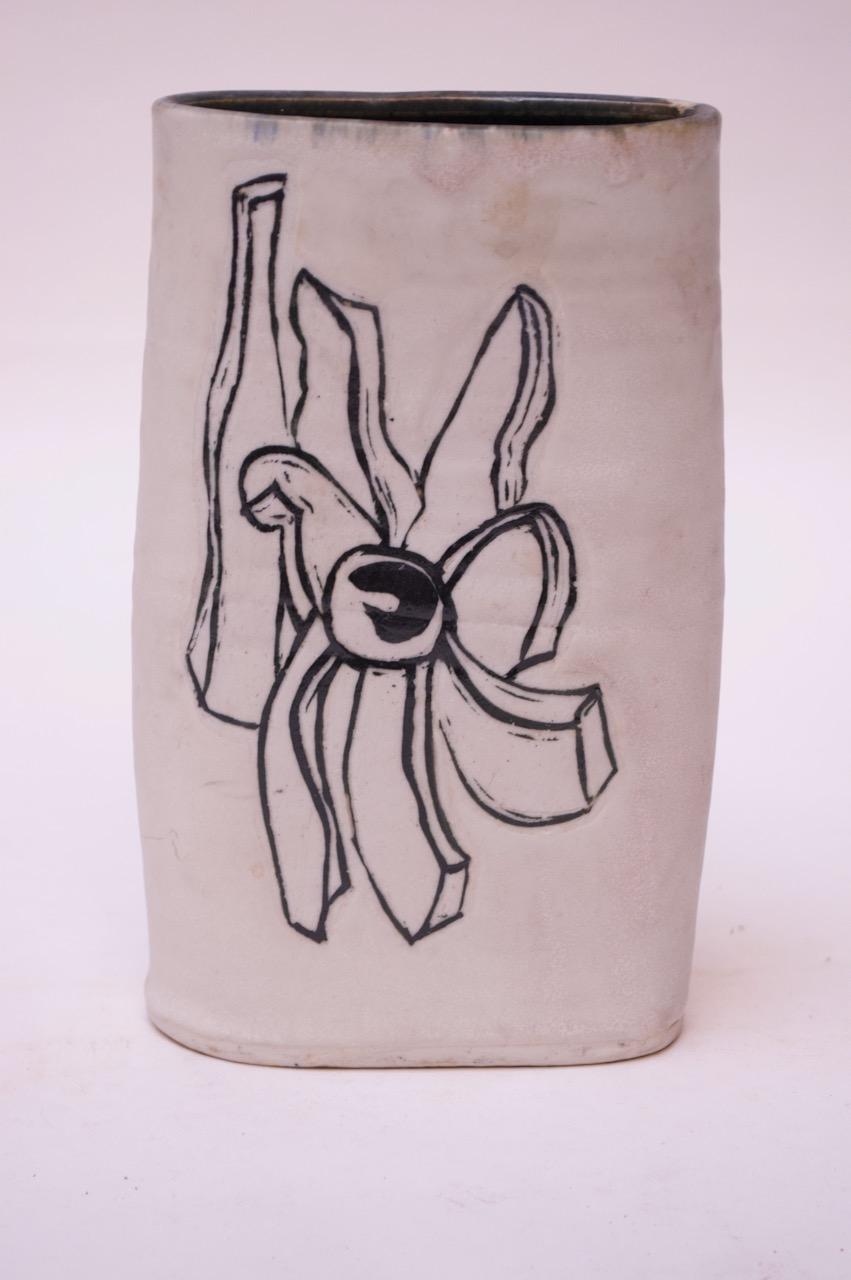 Black and white stoneware vase made in 1976 by ceramicist, Pollack. Matte white with black abstract floral decoration present on both sides. Signed 