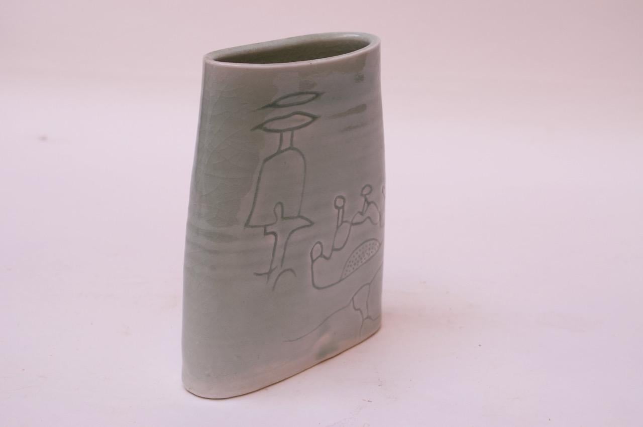 Pale green stoneware vase made in 1976 by ceramicist, Pollack. Abstract figural and floral decoration present on both sides. Signed 