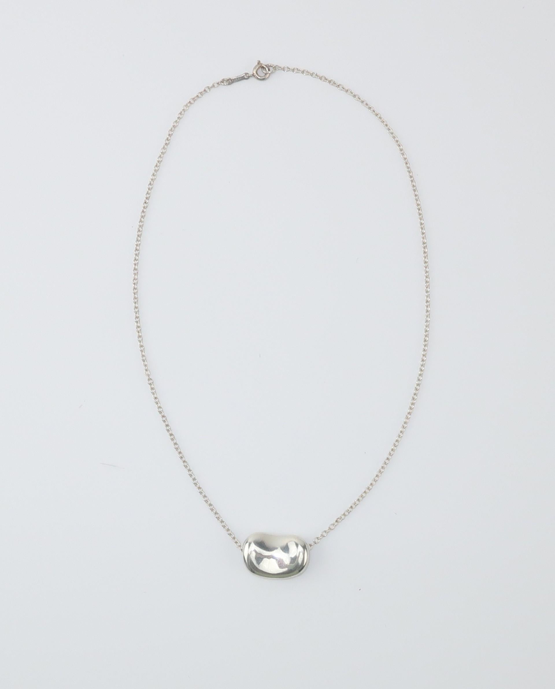 Elsa Peretti's iconic bean design for Tiffany & Company is a timeless classic.  The simple modernist bean represents the 'origin of all things' and is suspended from a delicate chain necklace.  This early sterling silver bean necklace is dated 1977