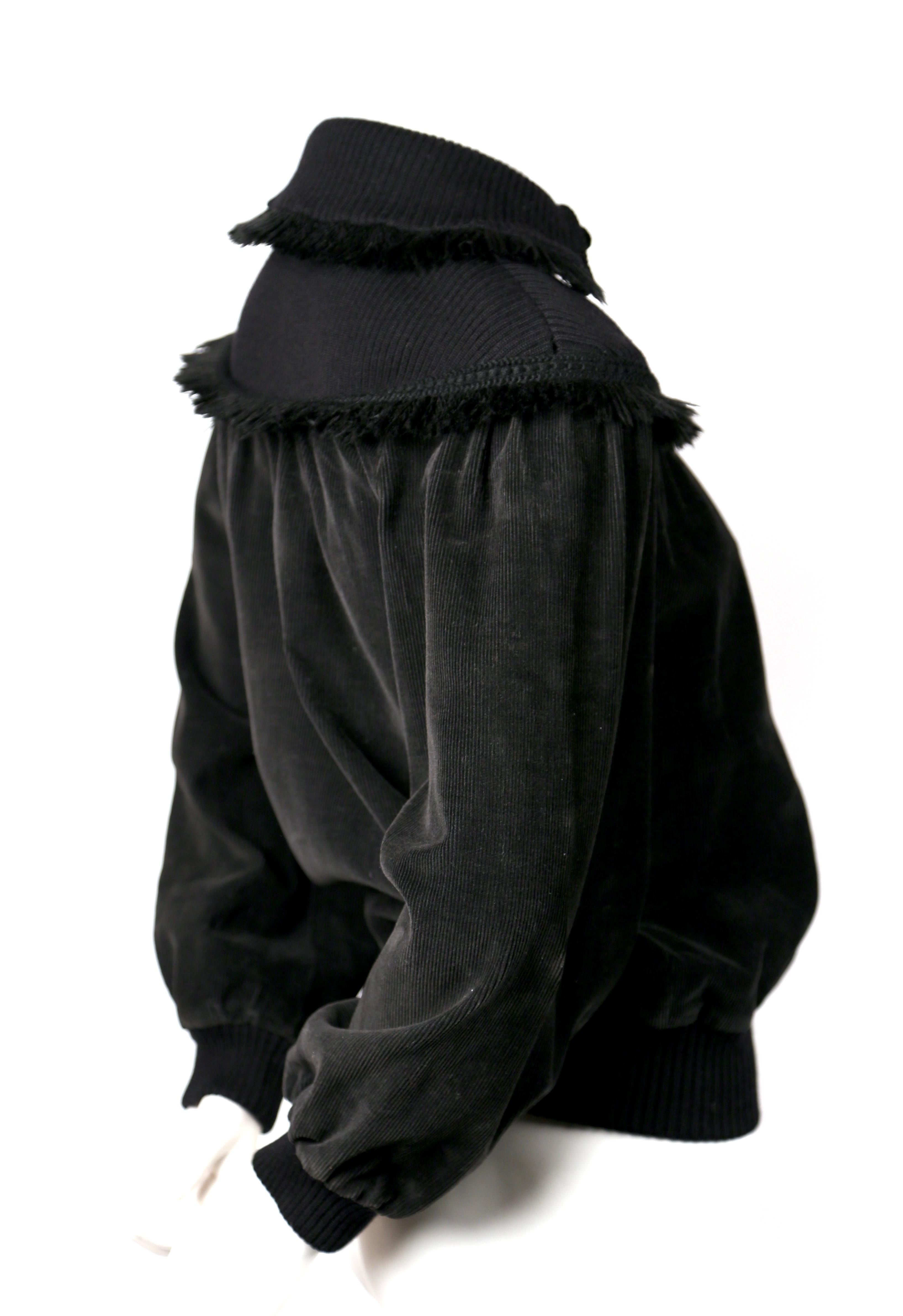 Très rare, pull-over en velours côtelé noir avec bordures frangées dessiné par Yves Saint Laurent datant de l'automne 1977, tel qu'il a été vu sur le défilé d'automne.  Taille française 34. Mesures approximatives : buste 36-38